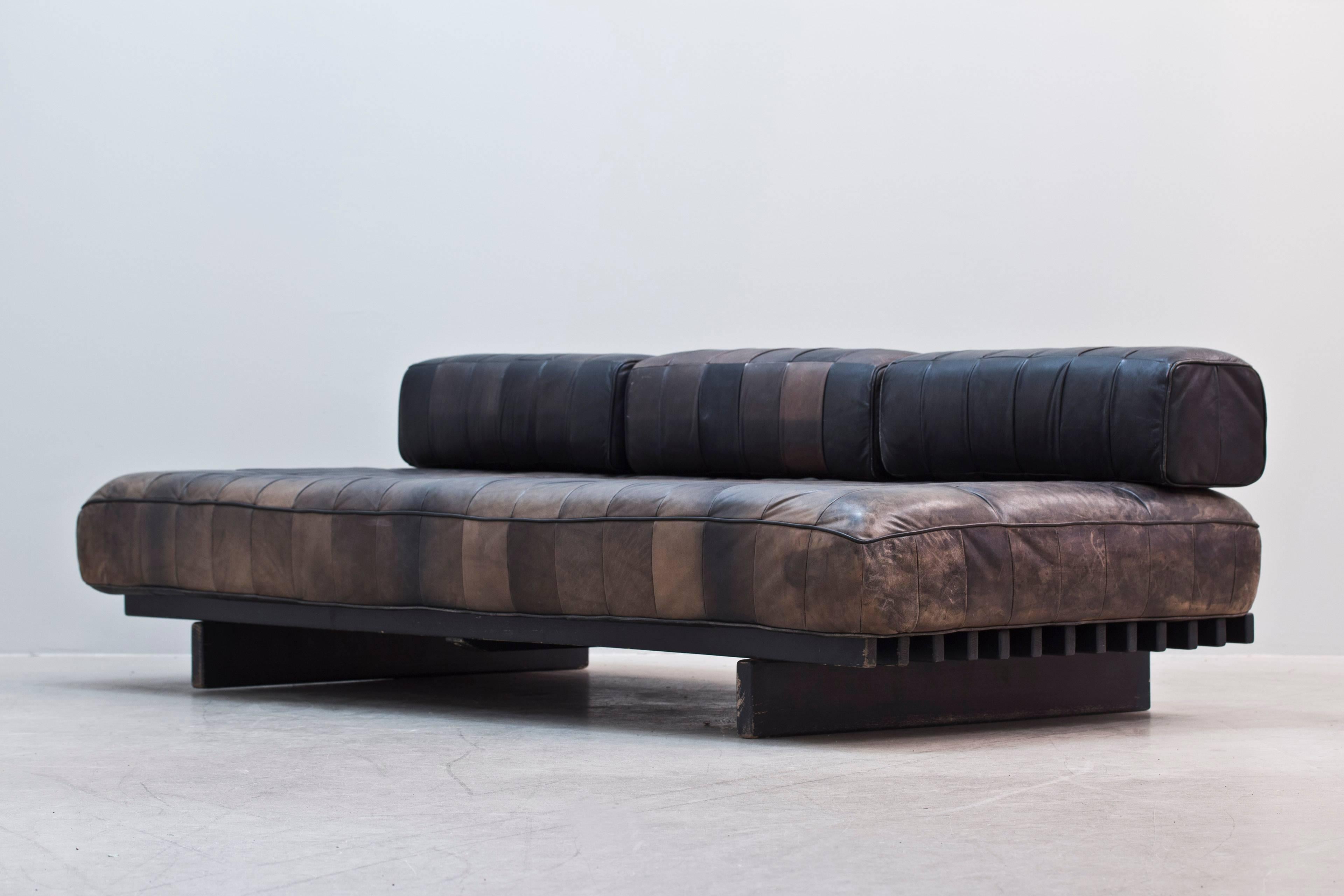 Patchwork brown leather daybed designed by De Sede in 1970s, Switzerland.
Black wood frame, loose mattress, three cushions covered in brown leather removable back support. 