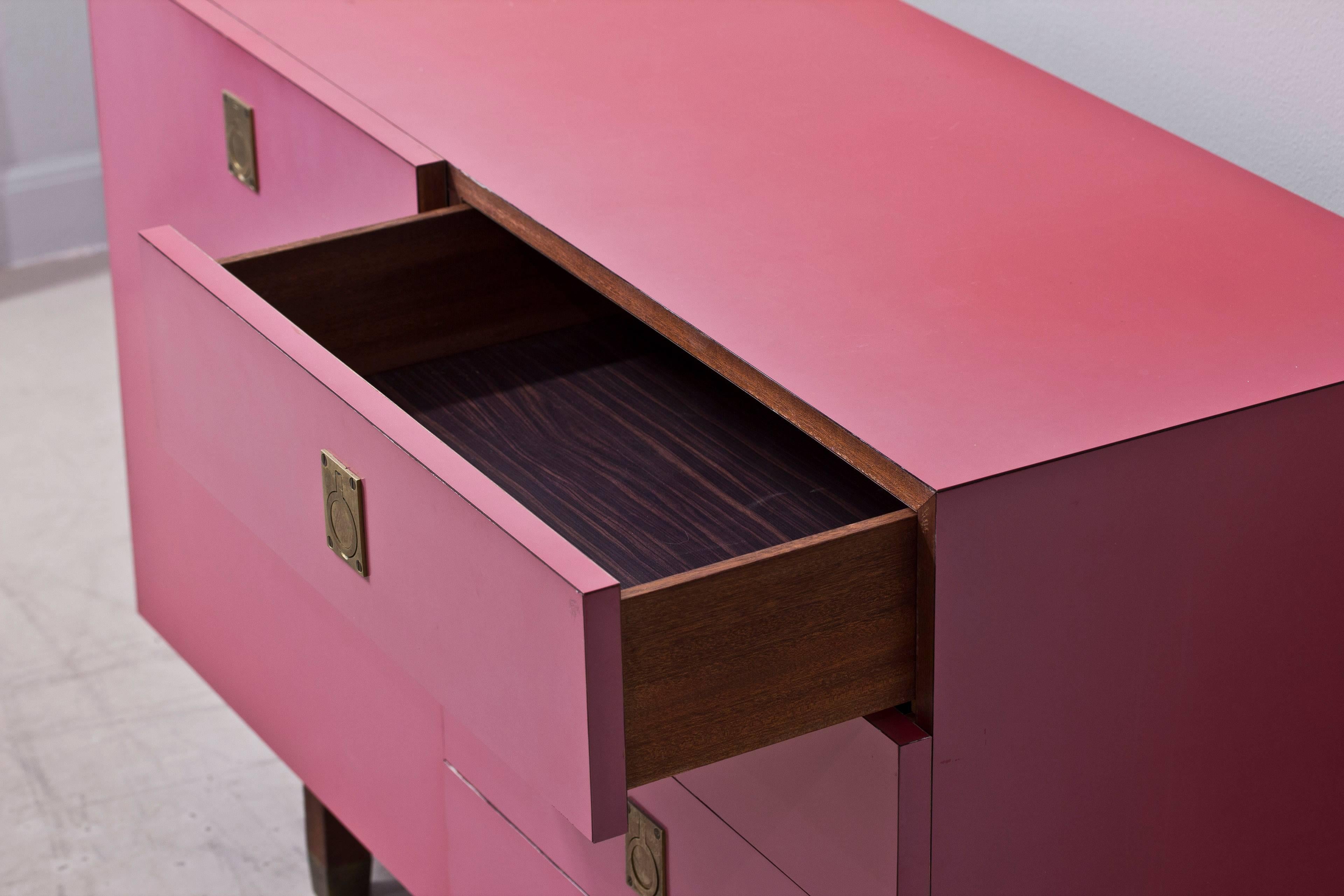 Pink sideboard with wooden legs and brass details, designed with door and four drawers.

Designer: Roger Thibier.
Year: 1950s.
Country: France.

Dimensions:

H: 46 cm
W: 120 cm
D: 46 cm.