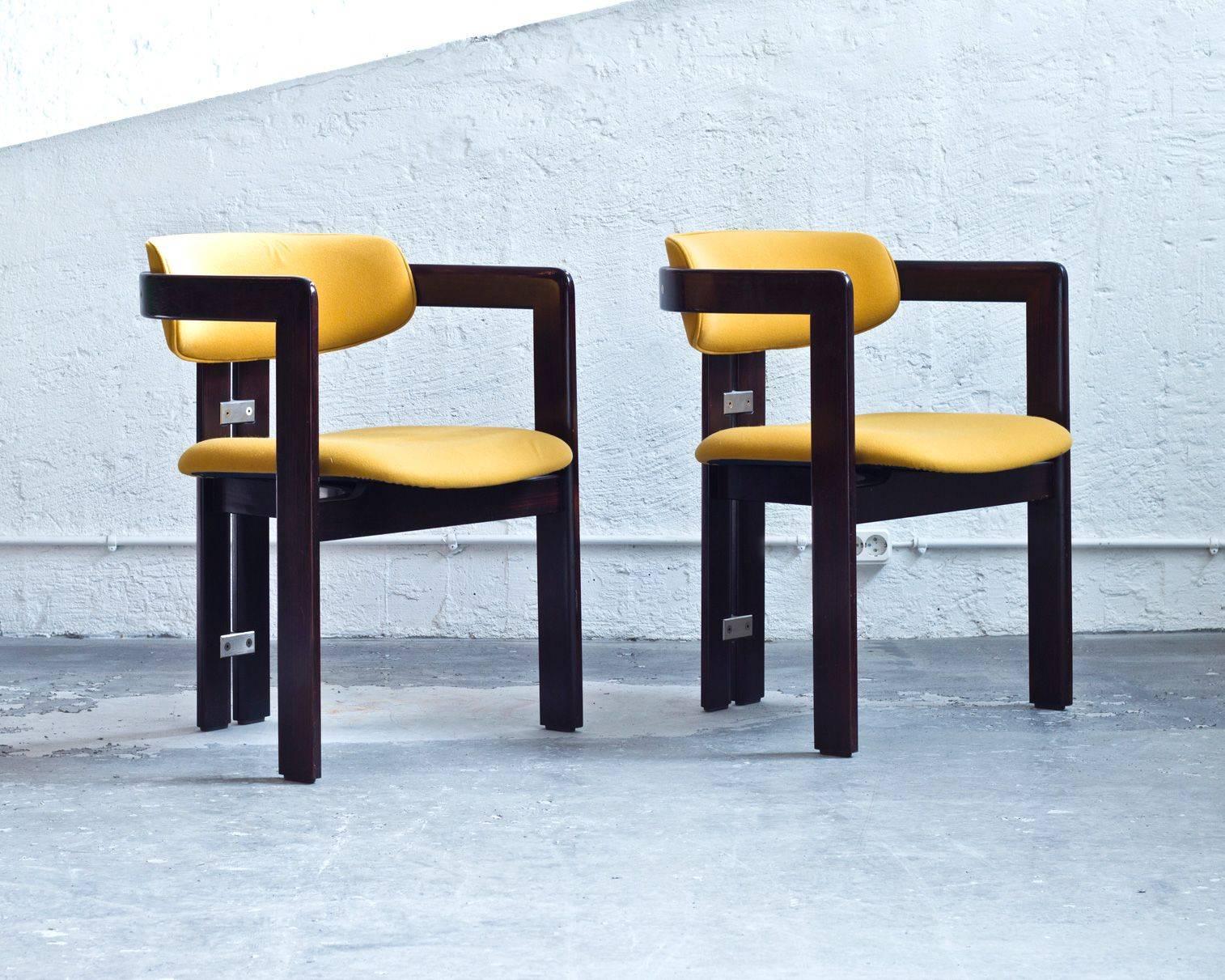 Set of two 'Pamplona' dining chairs in Italian walnut wood, details in stainless steel and upholstered in yellow wool fabric.
