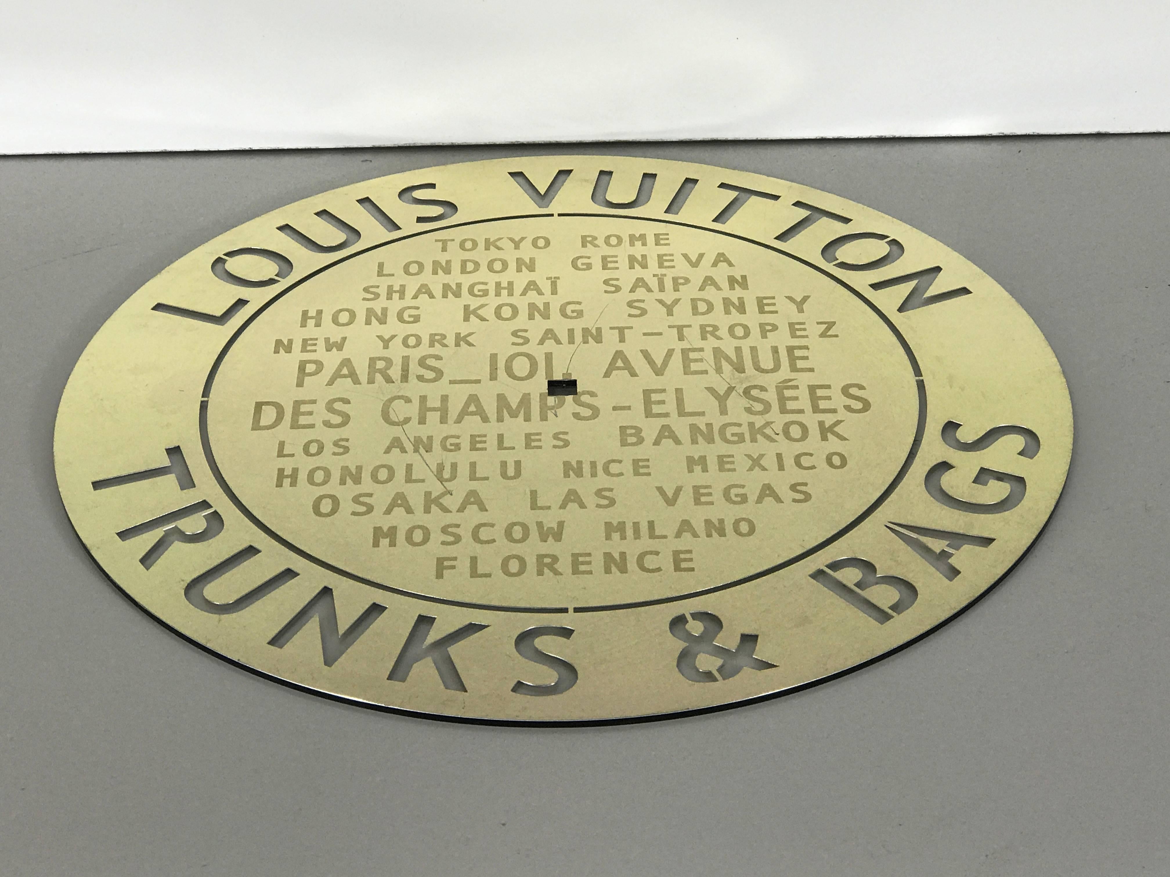Louis Vuitton store plaque, with center square hole for mounting.