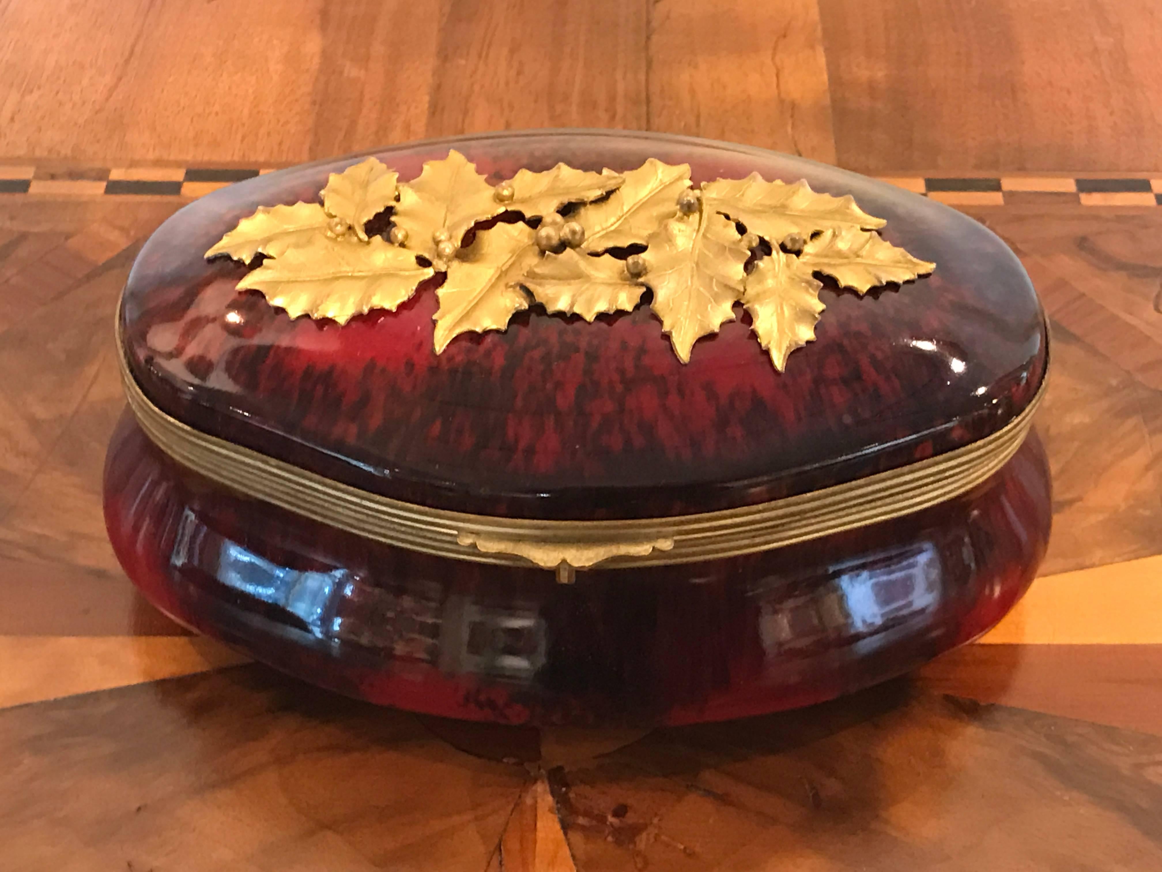 Sevres red flambe holly motif table box, with ormolu mounts. Rare color and motif.