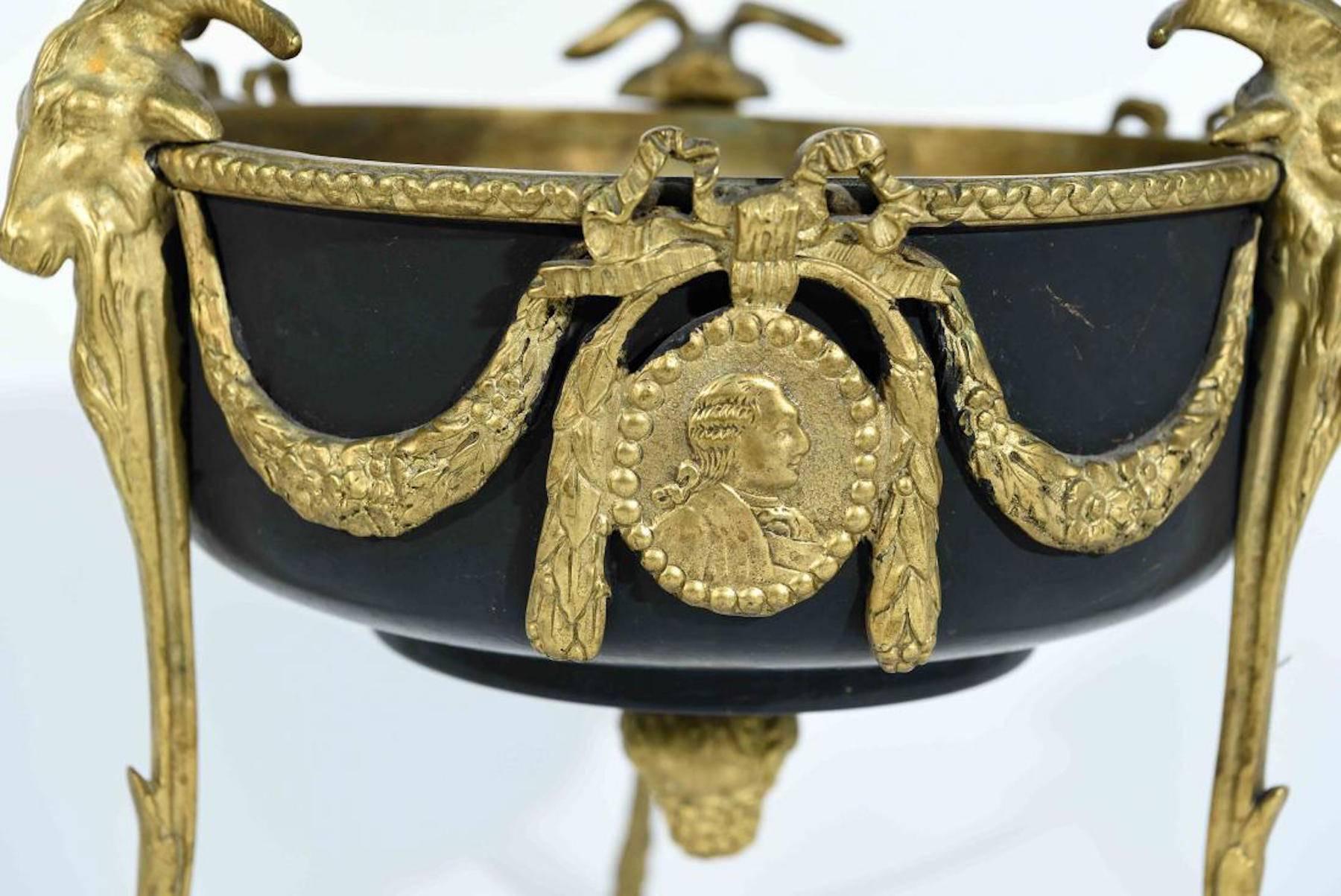 Louis XVI style centrepiece, of circular form with garlands and medallions raised on three ram motif hoofed legs.