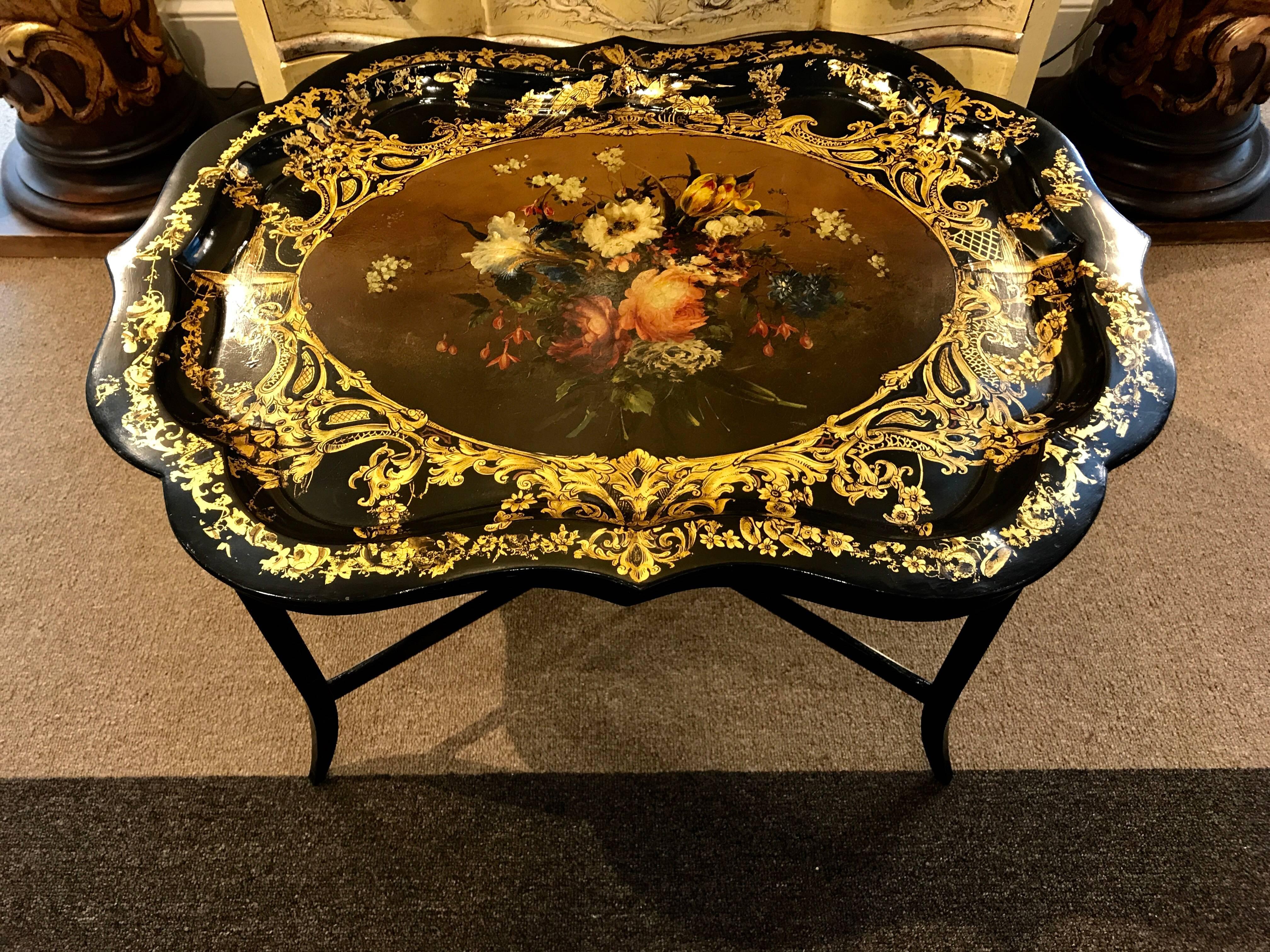 Stunning 19th century English papier mâché gilt floral tray, now as a table. Crisp all-over decoration, the scalloped tray with the gilt surround with foliate and fountain motif. The centre a vibrant large bouquet of yellow and rose-colored flowers.
