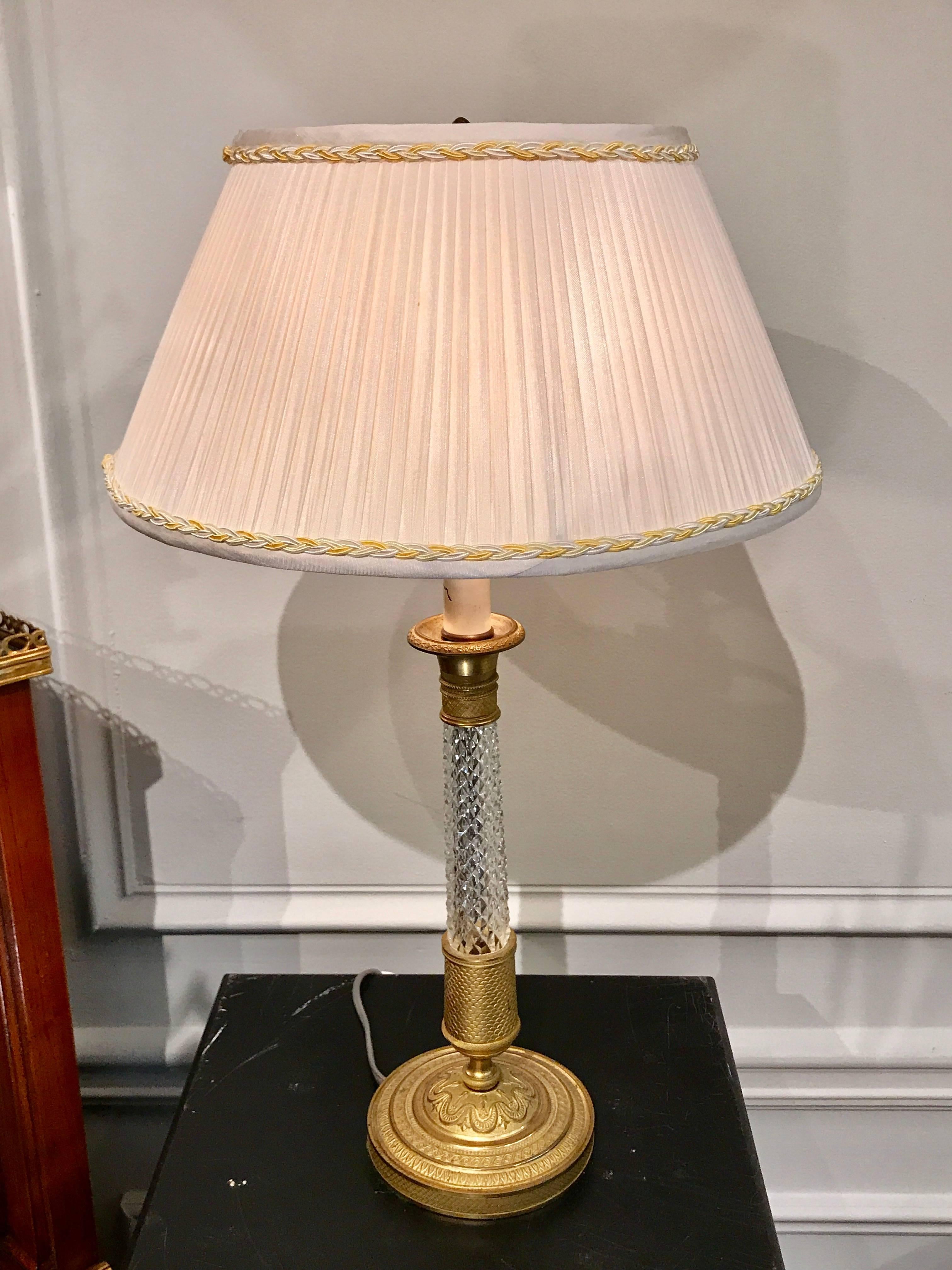 Each one of typical form with fine ormolu mounts and cut crystal 'sawtooth' column. This pair of lamps includes the vintage custom handmade shades.