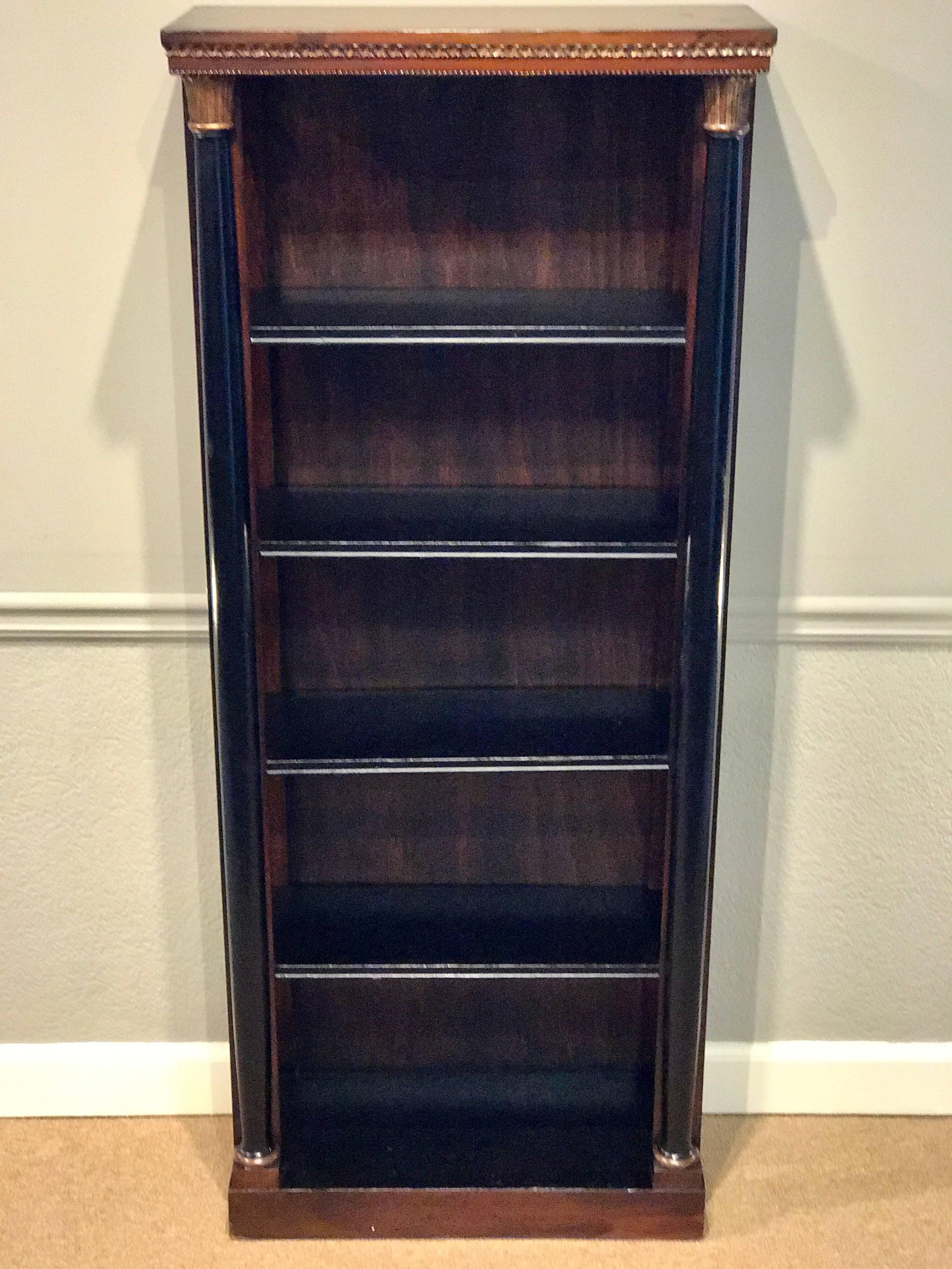 Regency style carved mahogany and giltwood bookcase, fitted with four 22.5 inch x 8-inch shelves flanked by carved mahogany and giltwood arrows.