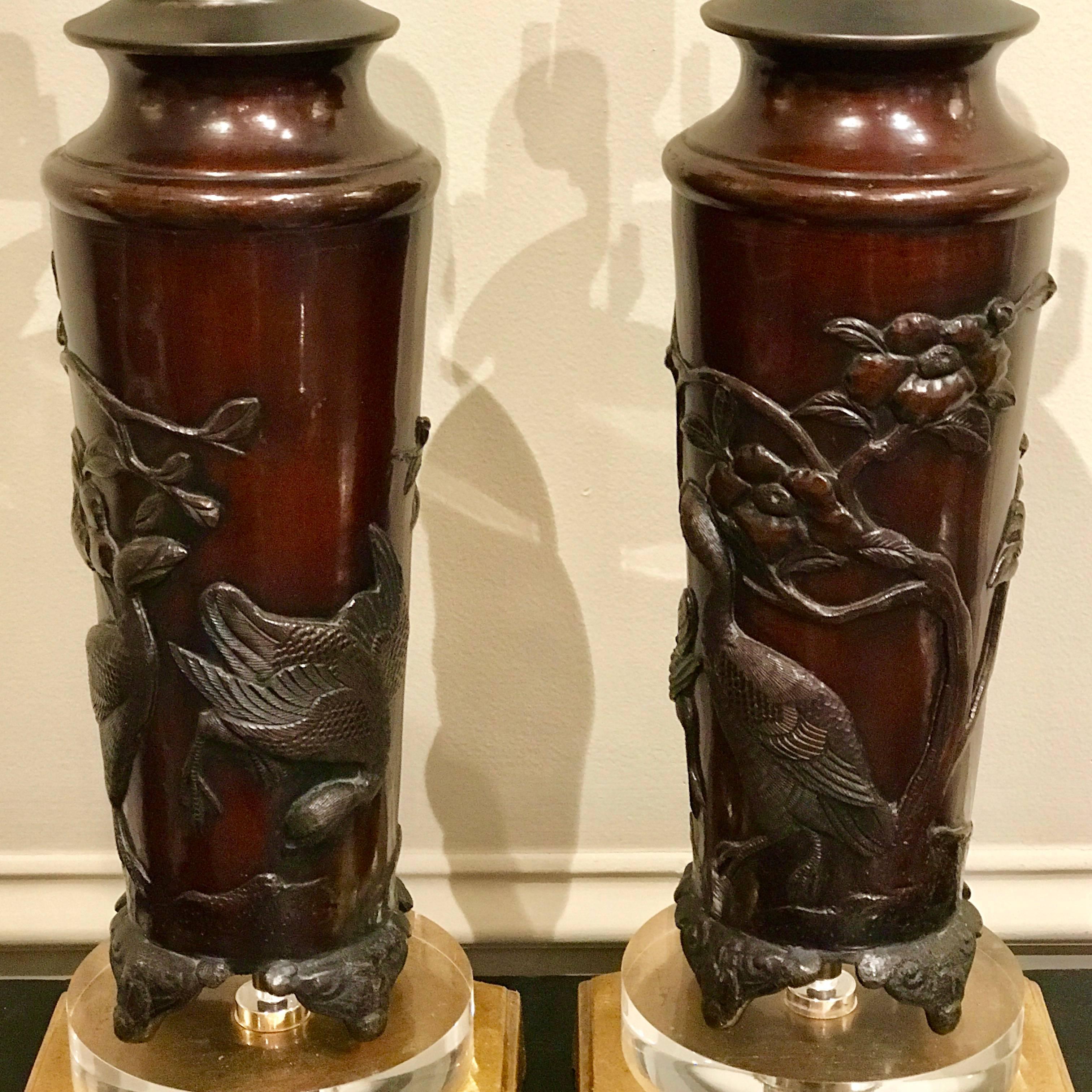 Pair of Chinese bronze bird motif vases, now as lamps, each one with finely chased bird and floral motif, raised on Lucite and giltwood bases. Beautiful rich patina.