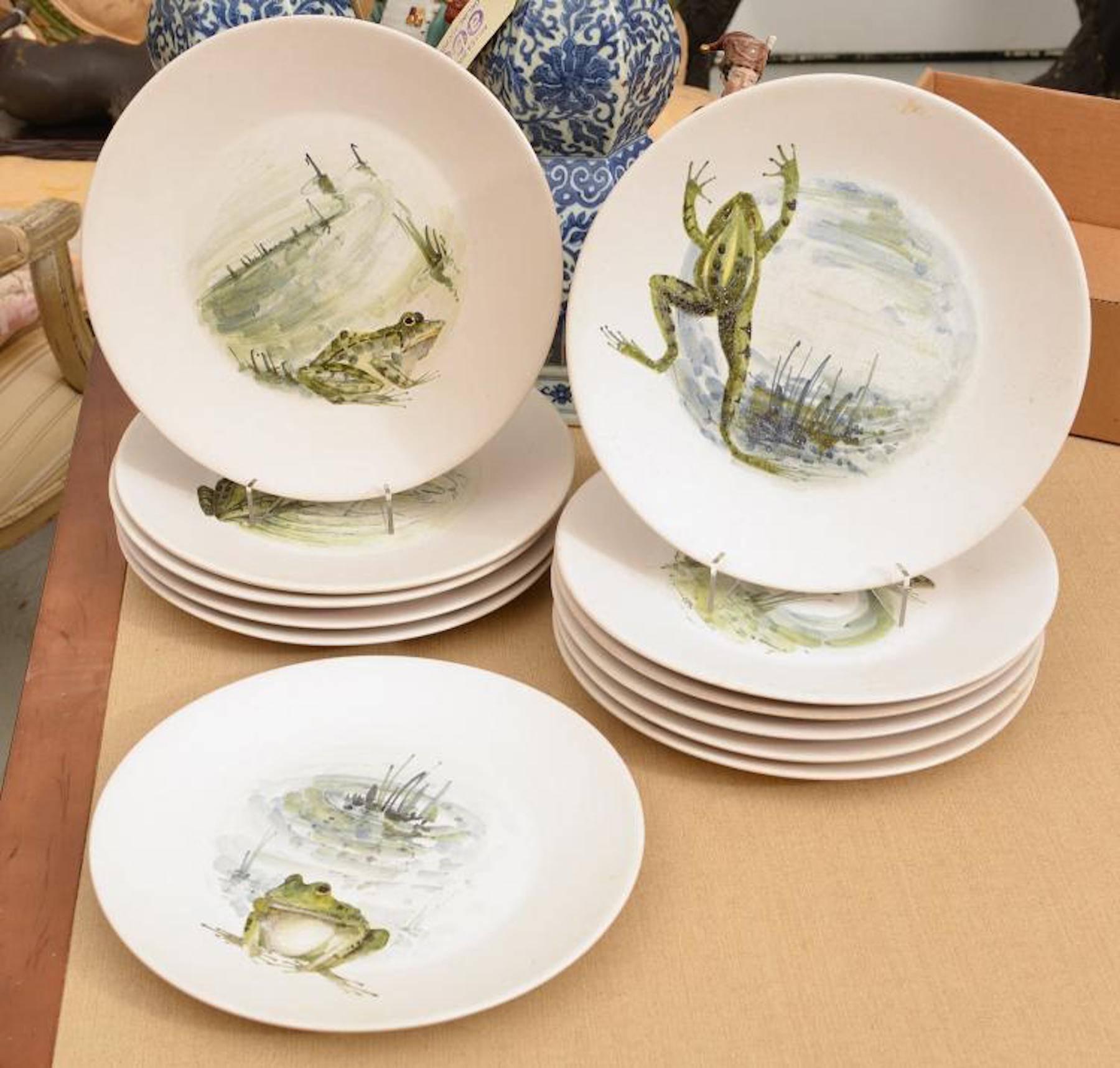 12 French frog motif plates by Marcel Guillot, hand-painted with 12 different vignettes of frogs in landscape.
 