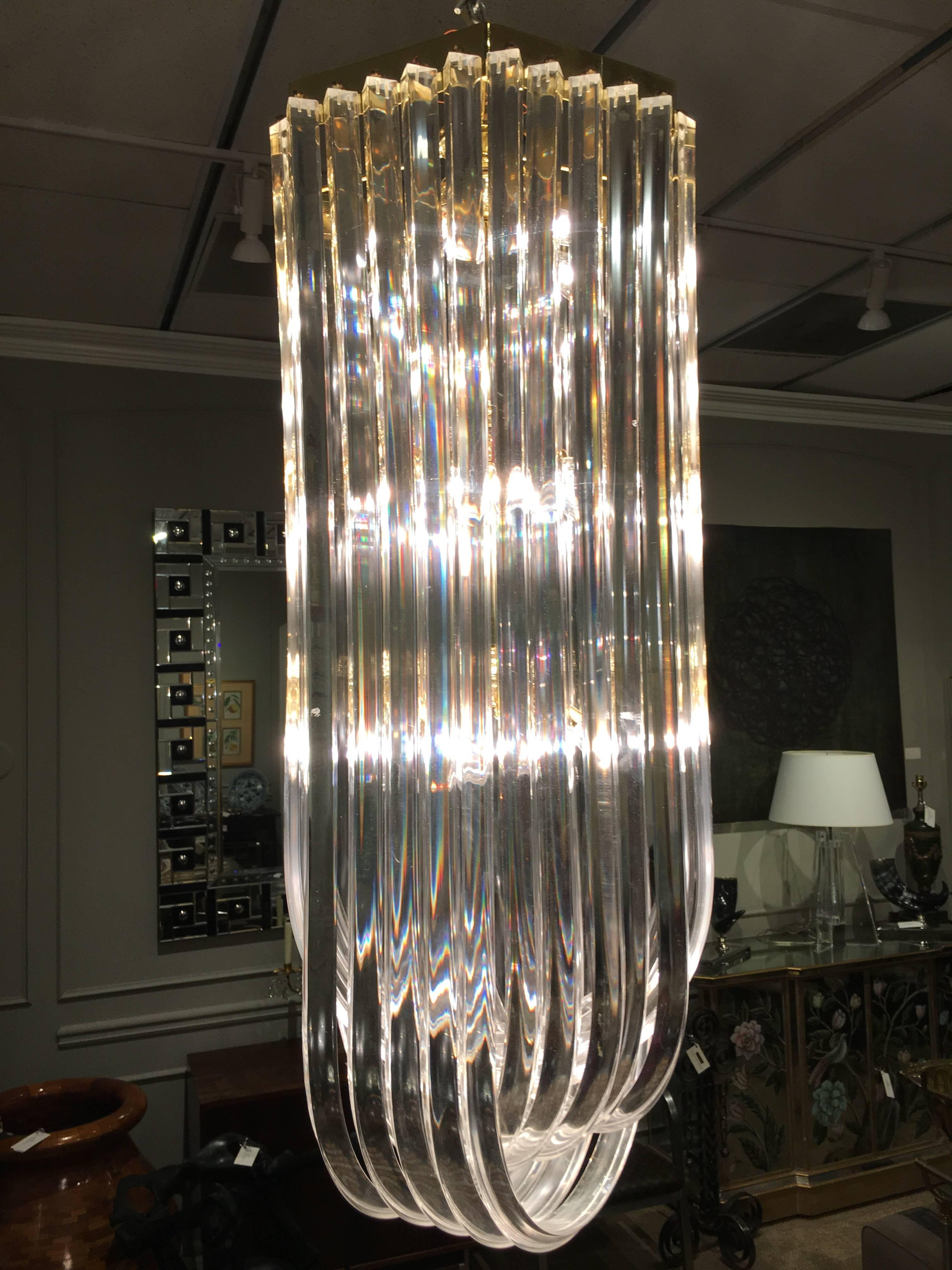 Extra-long Lucite ribbon chandelier with three rows of intertwining ribbons.