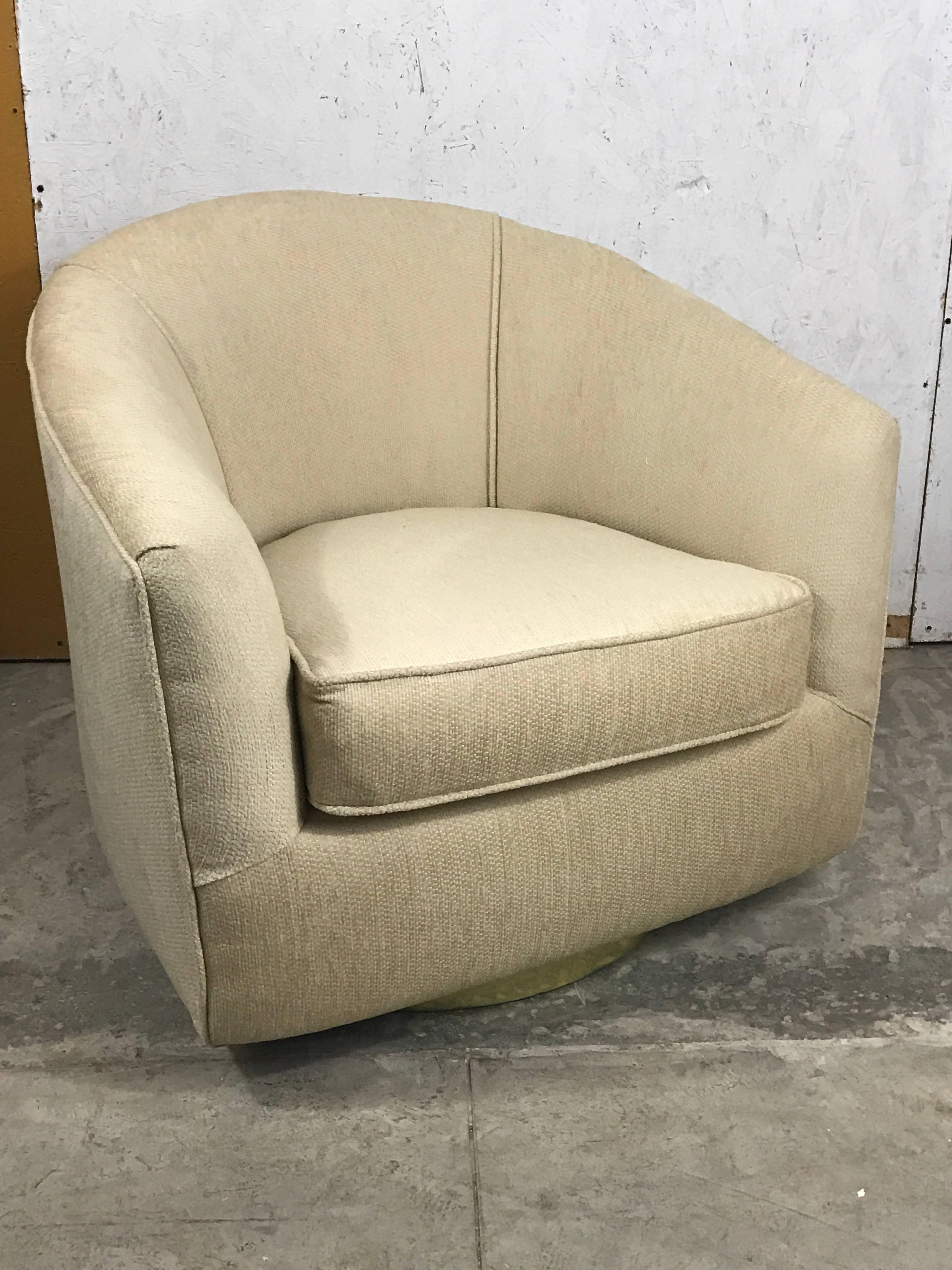 Pair of Milo Baughman swivel chairs, Each one with circular brass base.

Measures: 33” H x 30.5 D x 26.5” with 17.5” seat height (24” inside arm to arm).