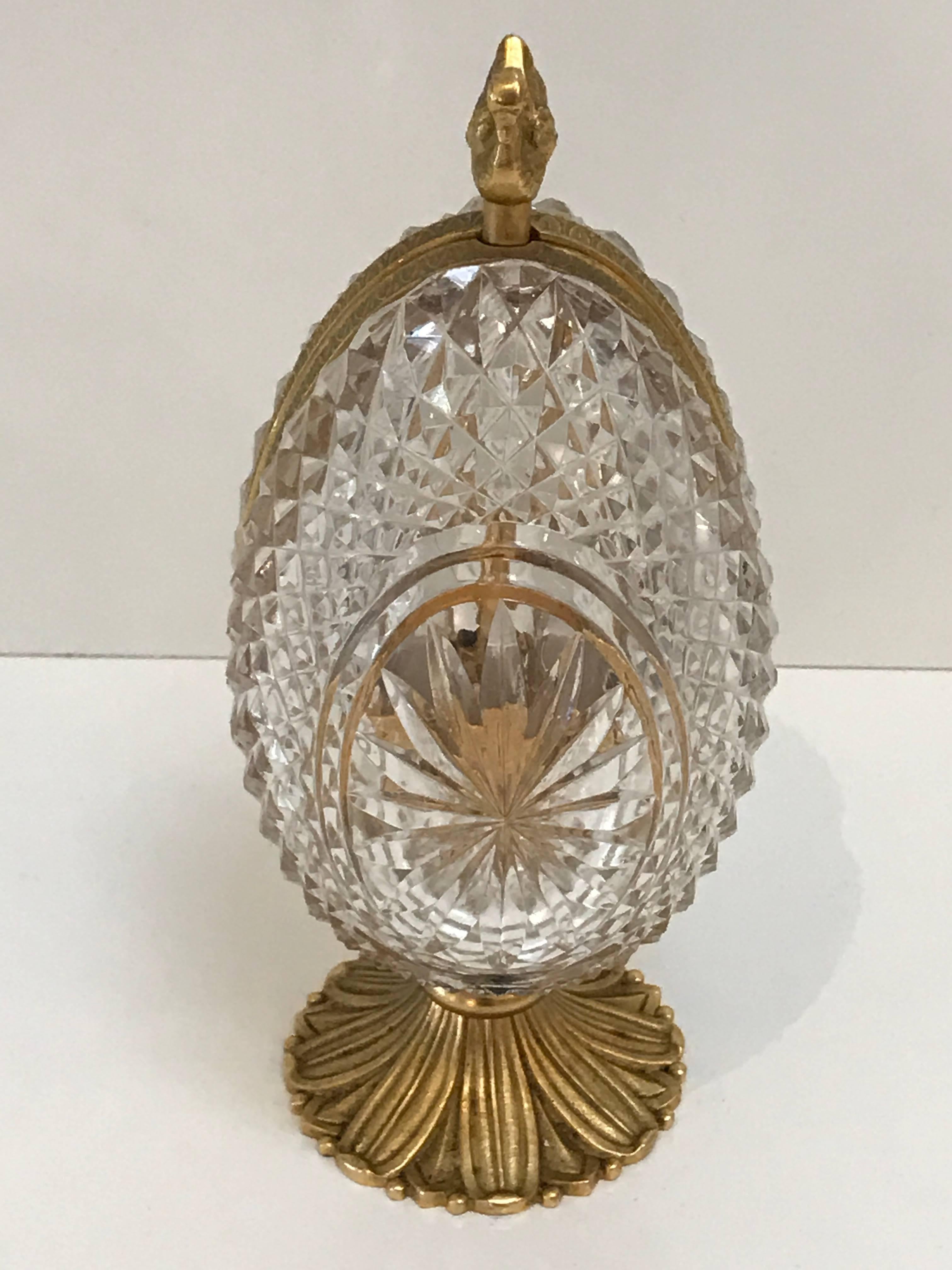 French ormolu-mounted crystal egg perfume with swan finial when pressed mechanically opens ( 6" wide) the egg to reveal two acid etched perfume bottles ( marked made in France) raised on a stylized acanthus base (2.5" d). Works well,