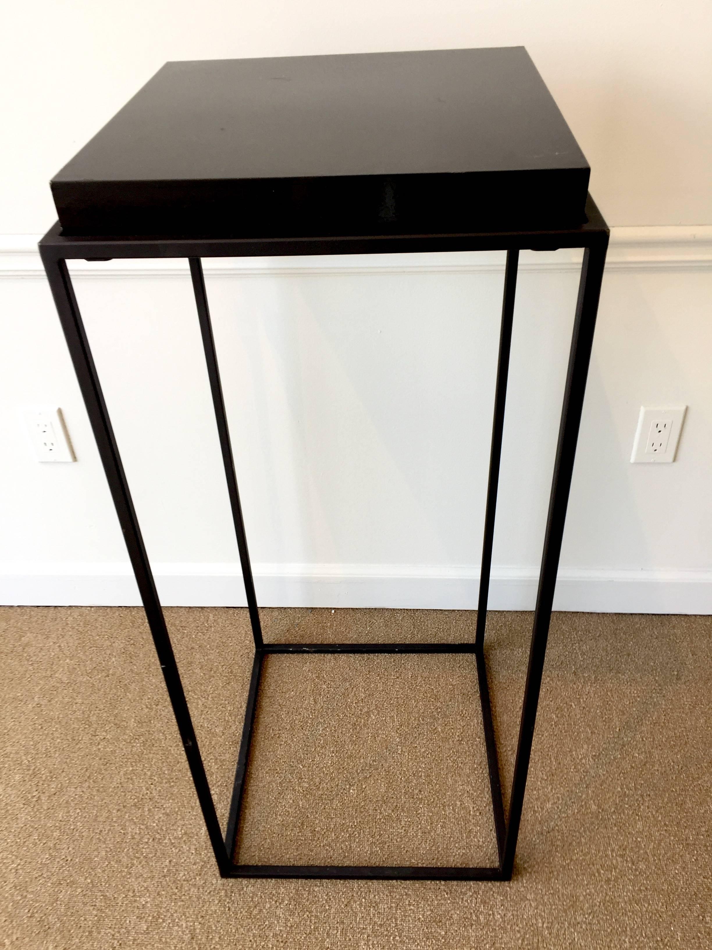 A pair of modern lacquer and iron modern pedestals, each one with a removable square lacquered plinth, raised on a four-column conforming pedestal base. Some minor scratches on the lacquer tops presents well.