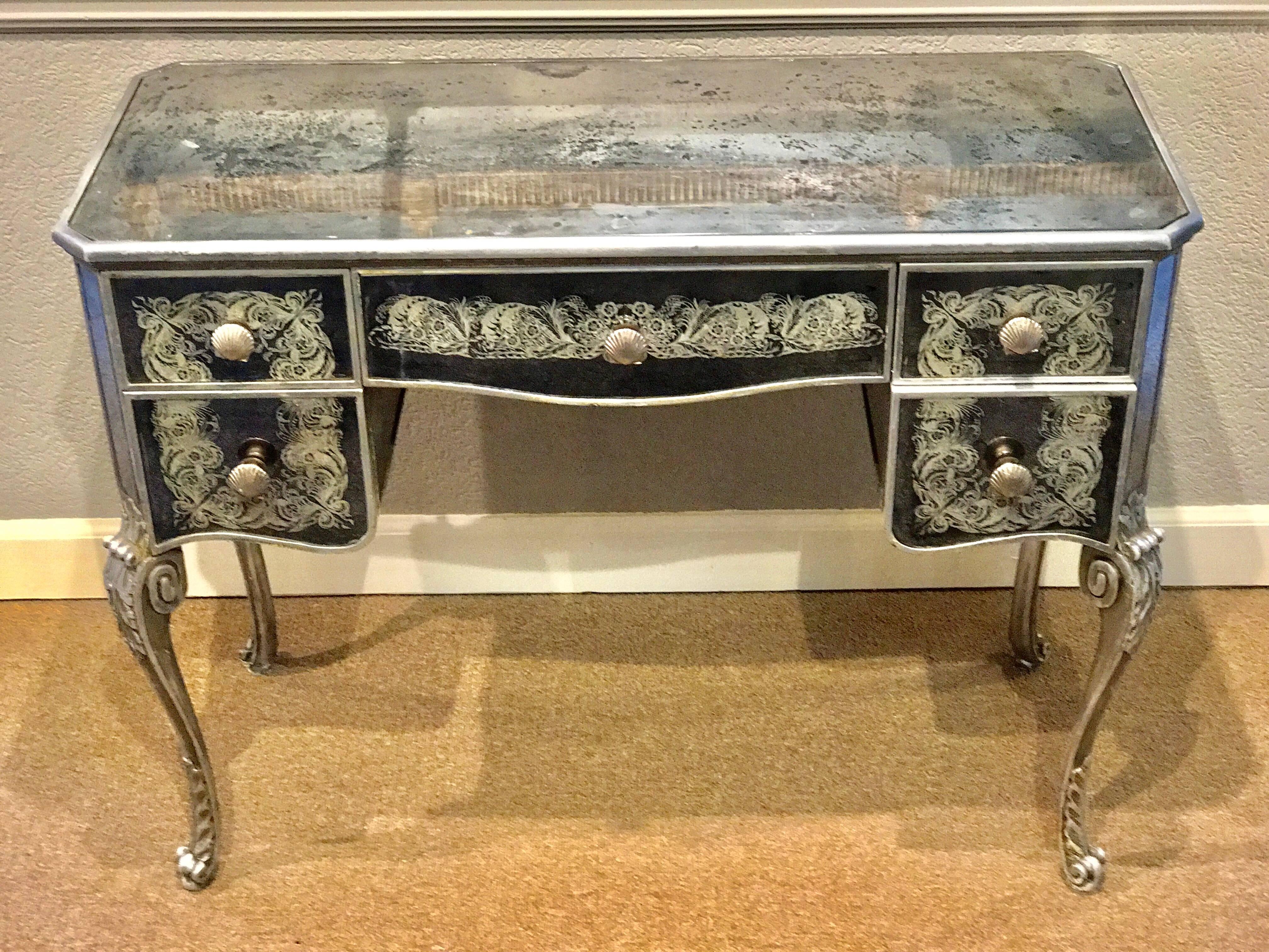 French Art Deco mirrored desk or vanity, beautiful proportions, silvered wood and verre églomisé mirror. Fitted with five drawers with silver plated bronze shell hardware. The opening measures 24
