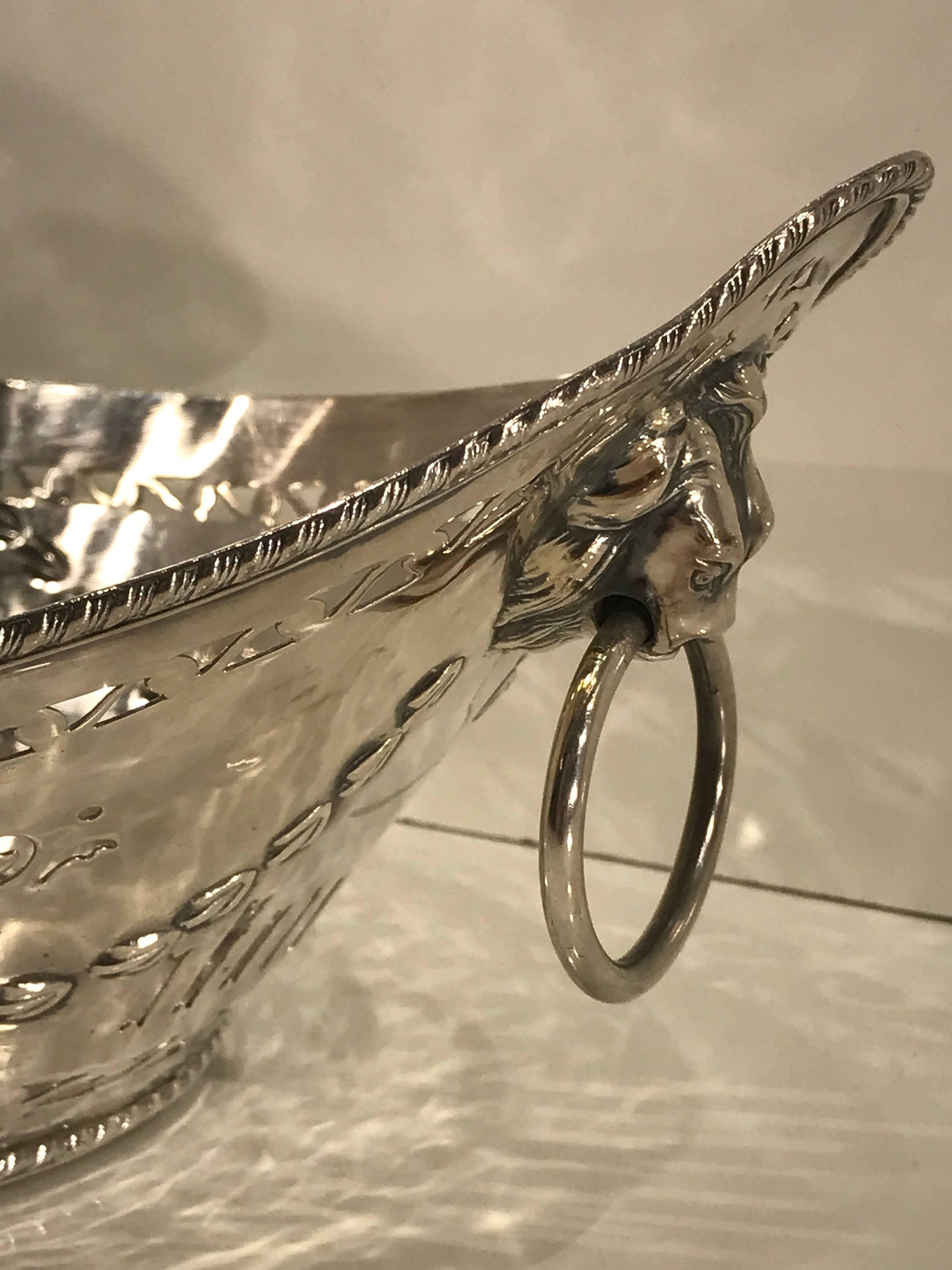 Antique Sheffield plated boat shaped pierced fruit basket with lion mask handles. Finely chased and repoused with pierced body, with lion mask ring handles at each end. Fine antique condition the silver is mostly intact, presents well. Not Marked.