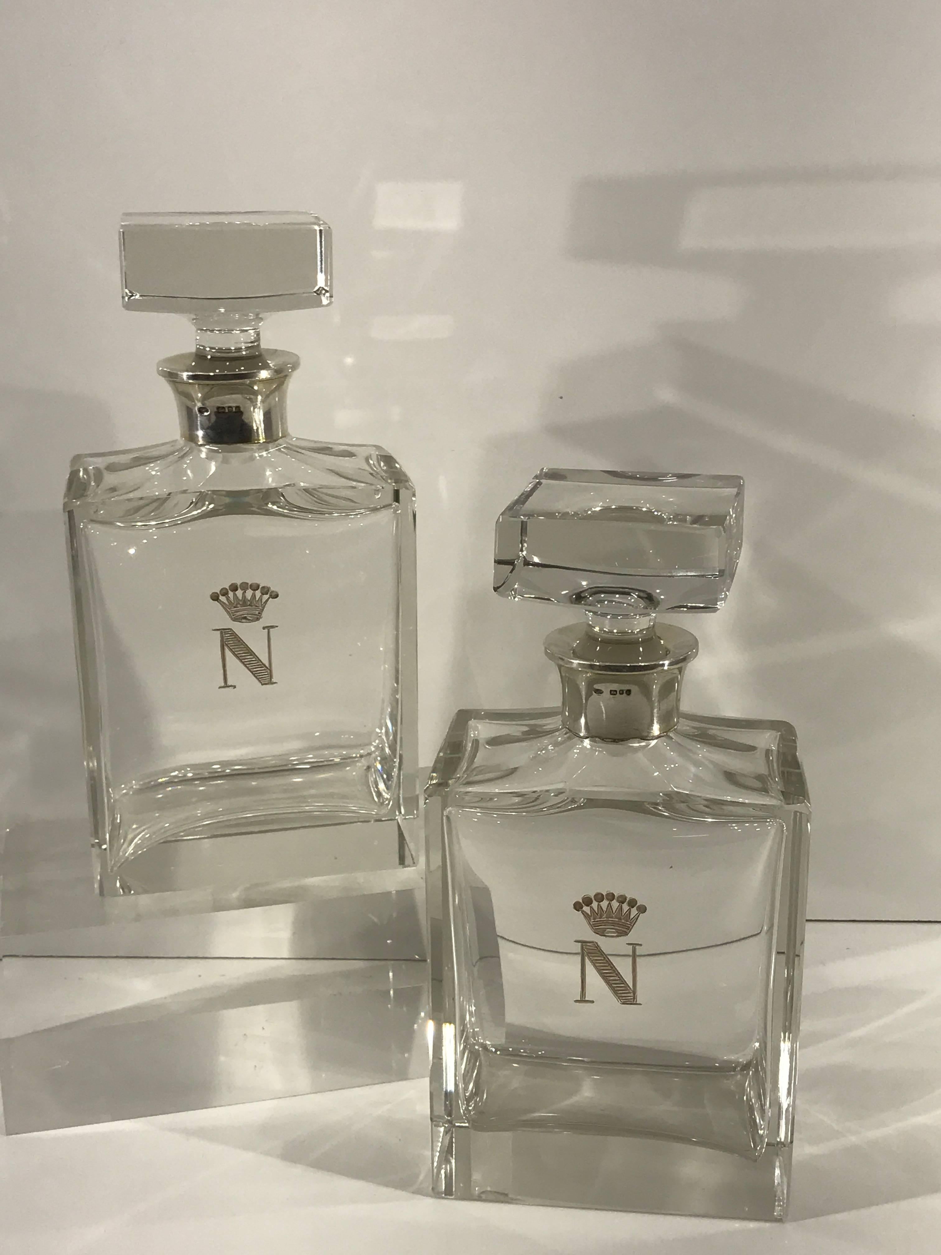 A pair of English sterling mounted crystal decanters with Napoleonic coat of arms. Each one of superb quality and substantial weight with 2.5-inch square stoppers, on a thick cut crystal sterling mounted bottles. Hallmarked for London, 1979, Stamped