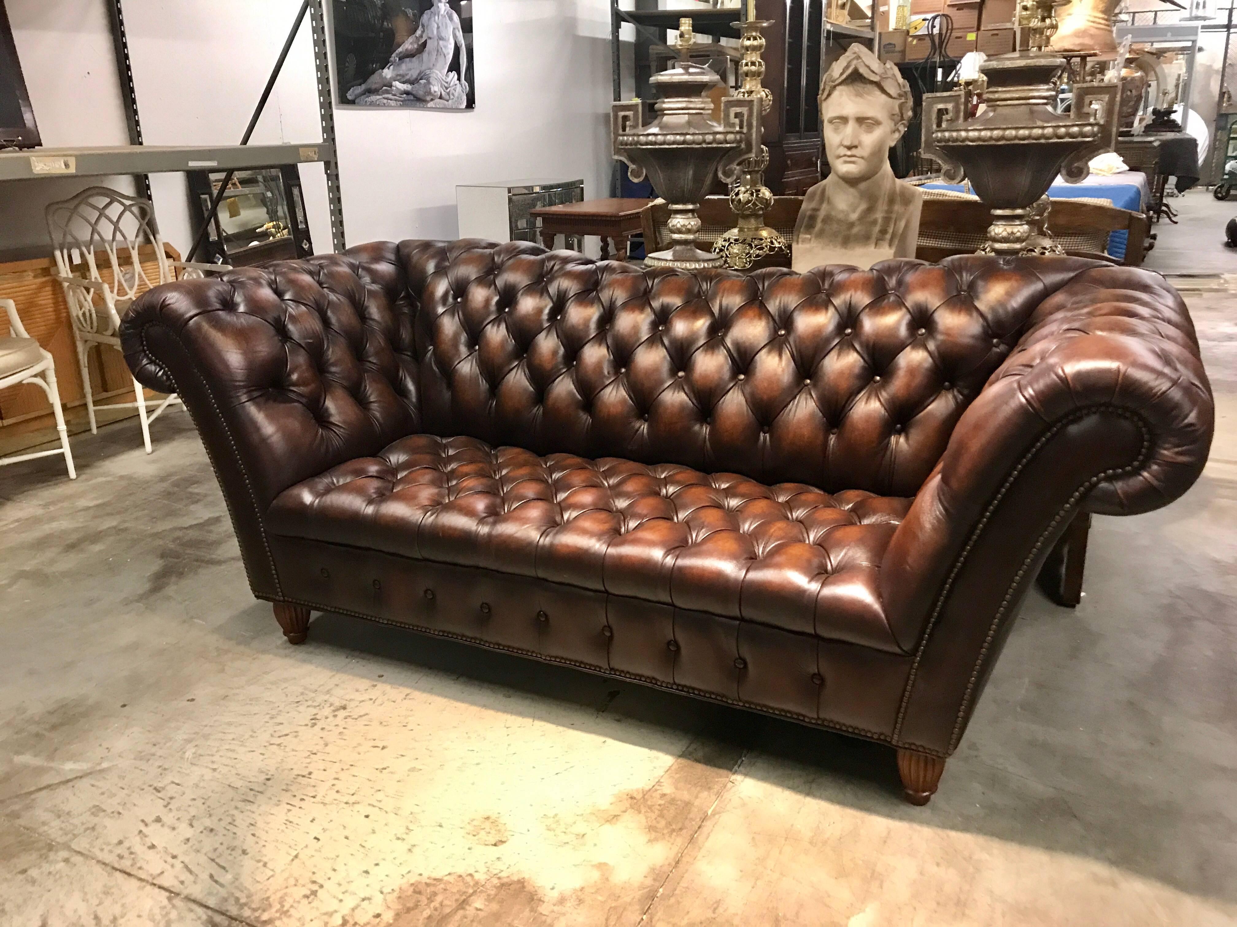 Sumptuous leather Chesterfield sofa with rolled arms raised on reeded bun feet.


 