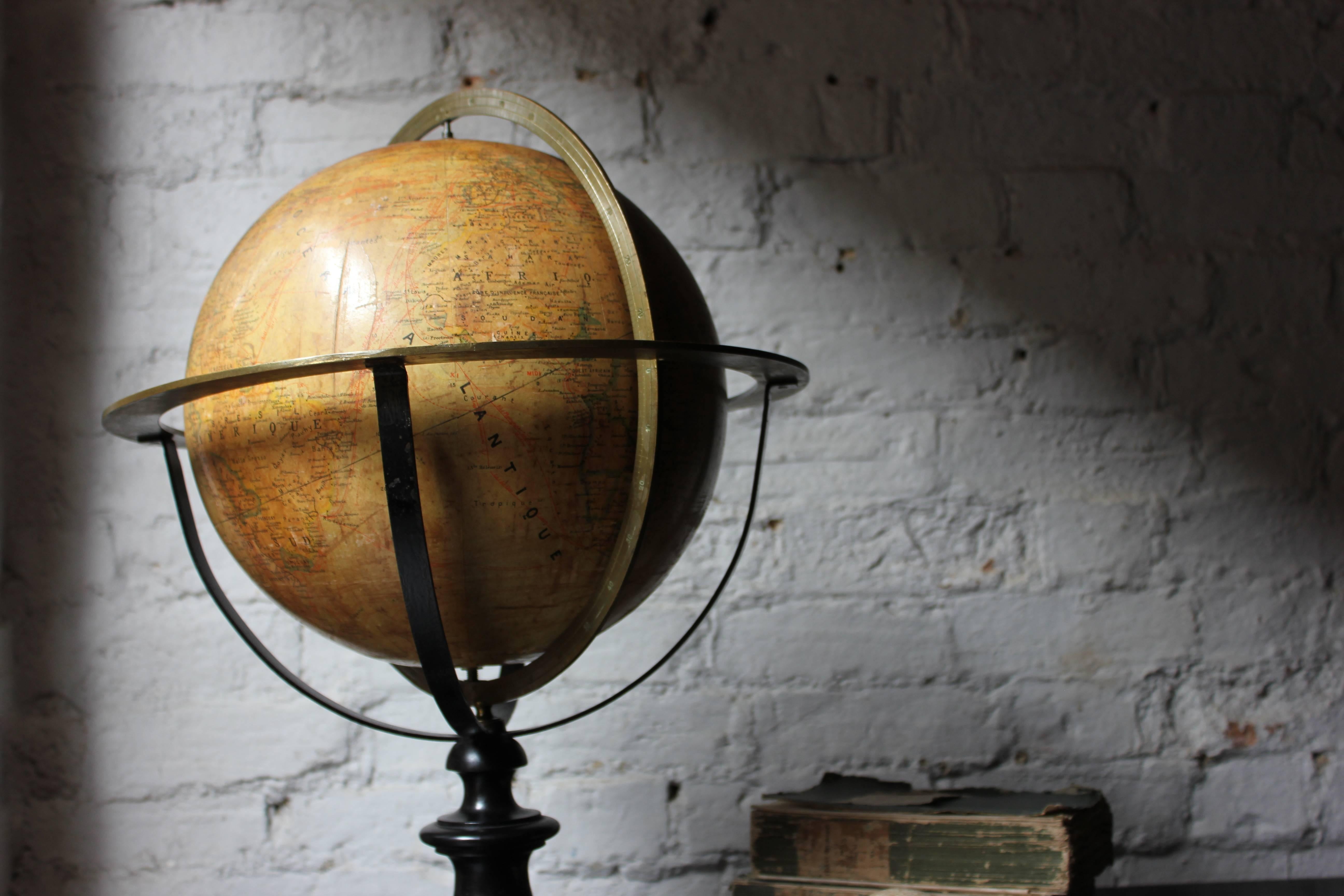 The attractive and well proportioned paper, plaster and cardboard, fourteen-inch terrestrial table globe concerned with physics, politics and history, rotating in a calibrated brass basket frame with brass meridian circle, horizon ring and hour
