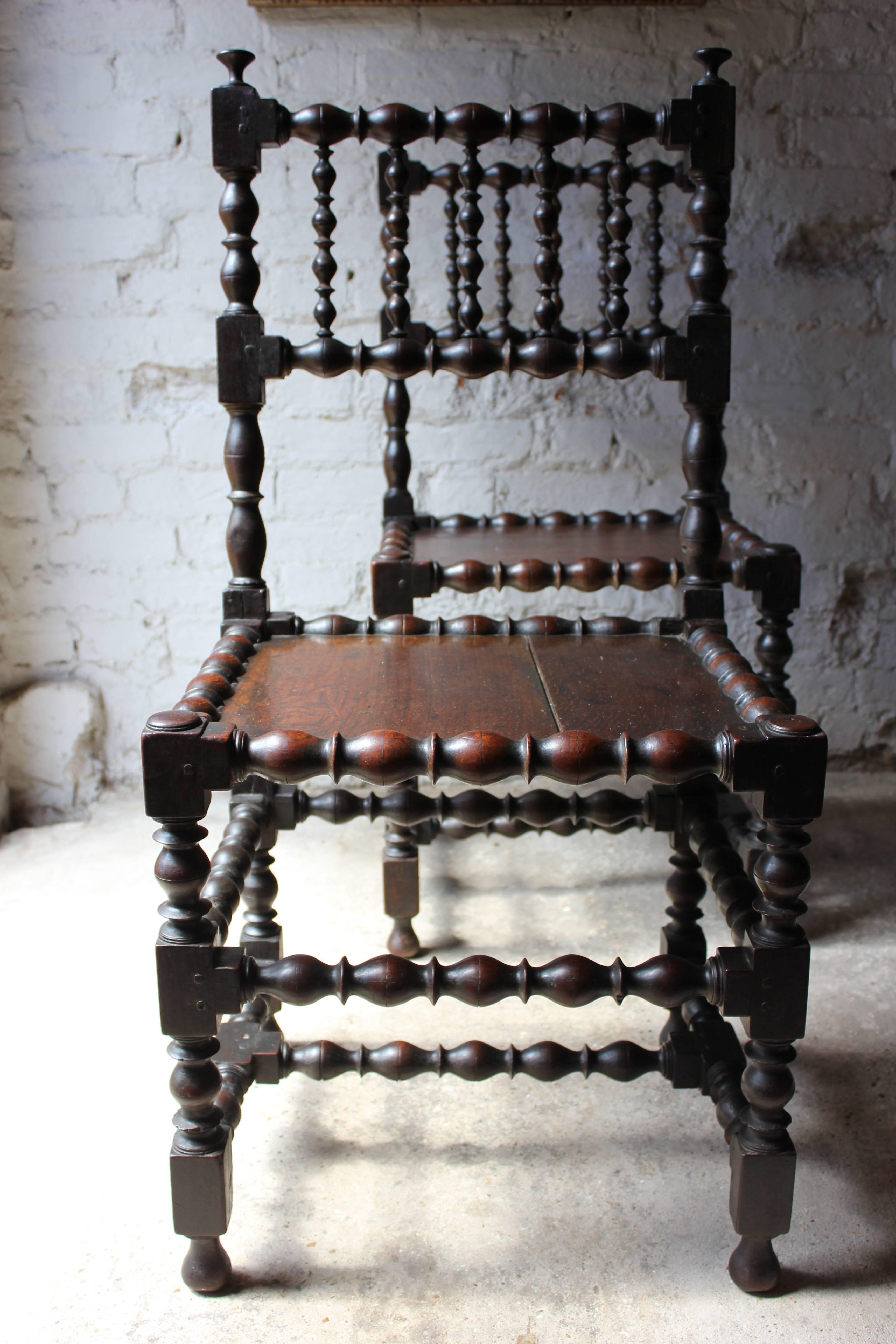 The 17th century oak joined spindle-back side chairs of good color each with all parts precisely elongated-ball and ring-turned, with panelled seats, and unusually, a mid-stretcher to all sides, together with a more conventional low H-form