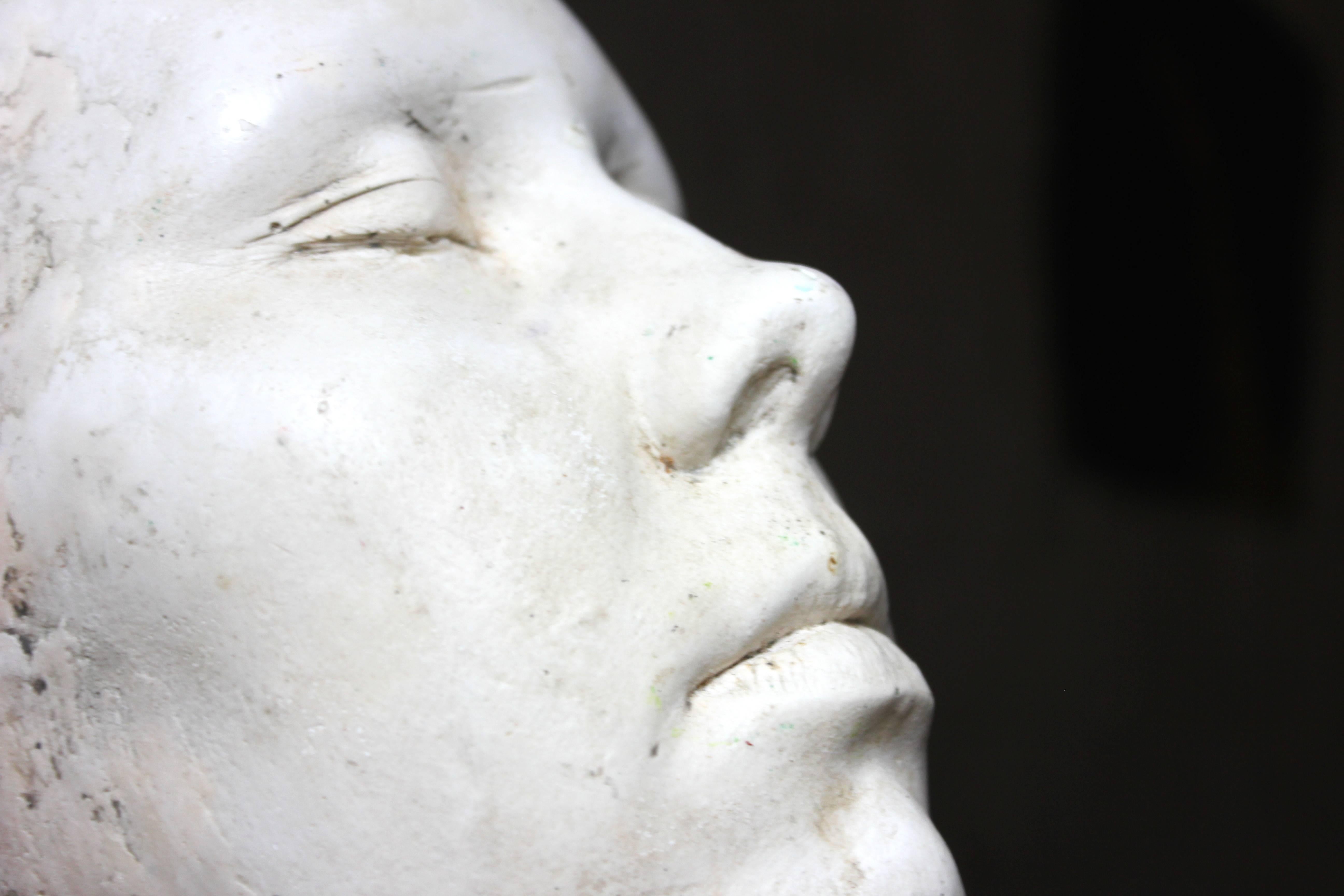 The lifesize thick heavy set plaster moulded death mask, well cast of a female, showing her in the serenity of passing and of particularly substantial proportions and clean lines, surviving from the first half of the 20th century and being
