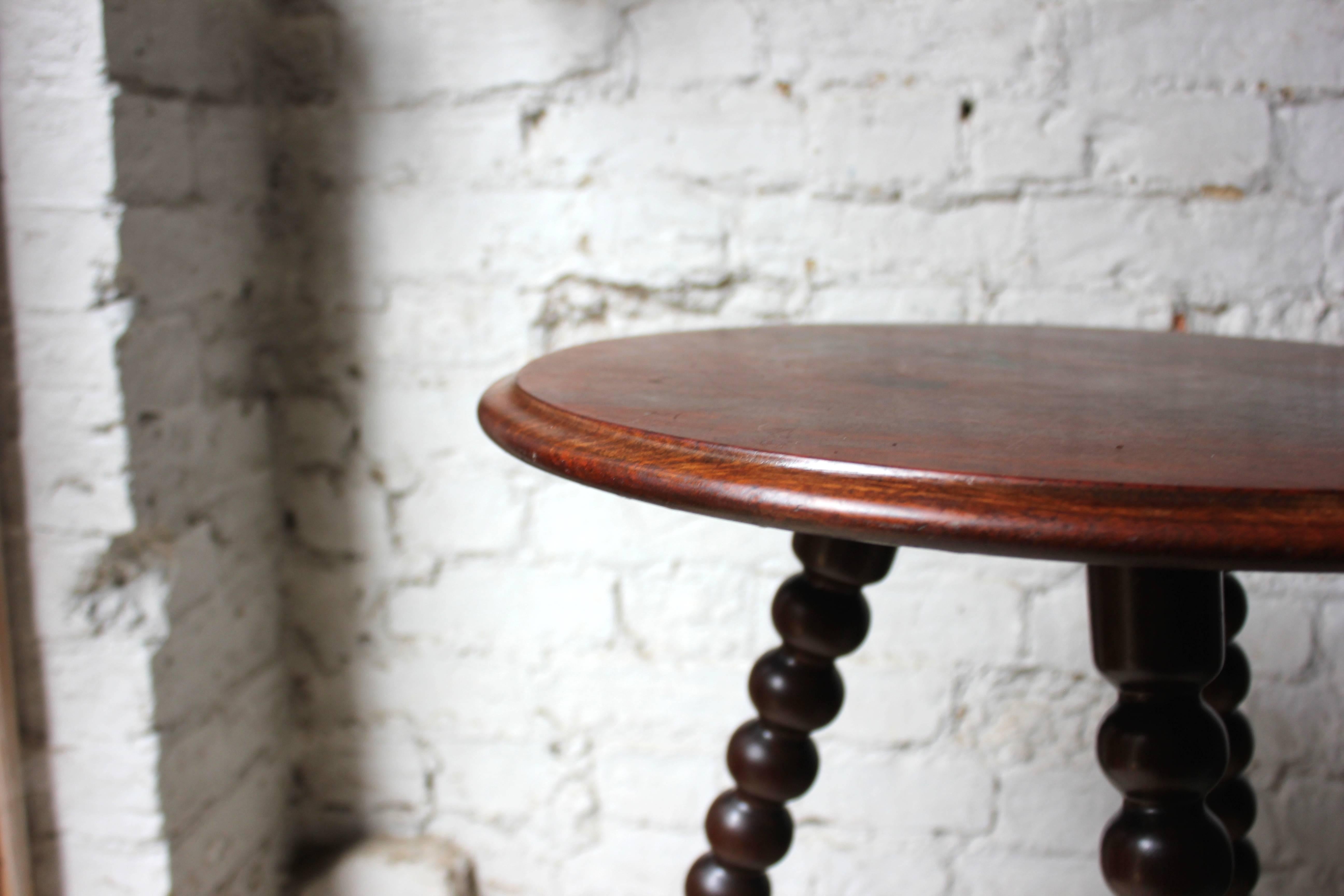 The walnut bobbin table of good color with a mahogany circular top supported by three bobbin-turned legs, surviving from last quarter of 19th century, England.

The table is structurally sound and stabile, with the expected surface wear with a