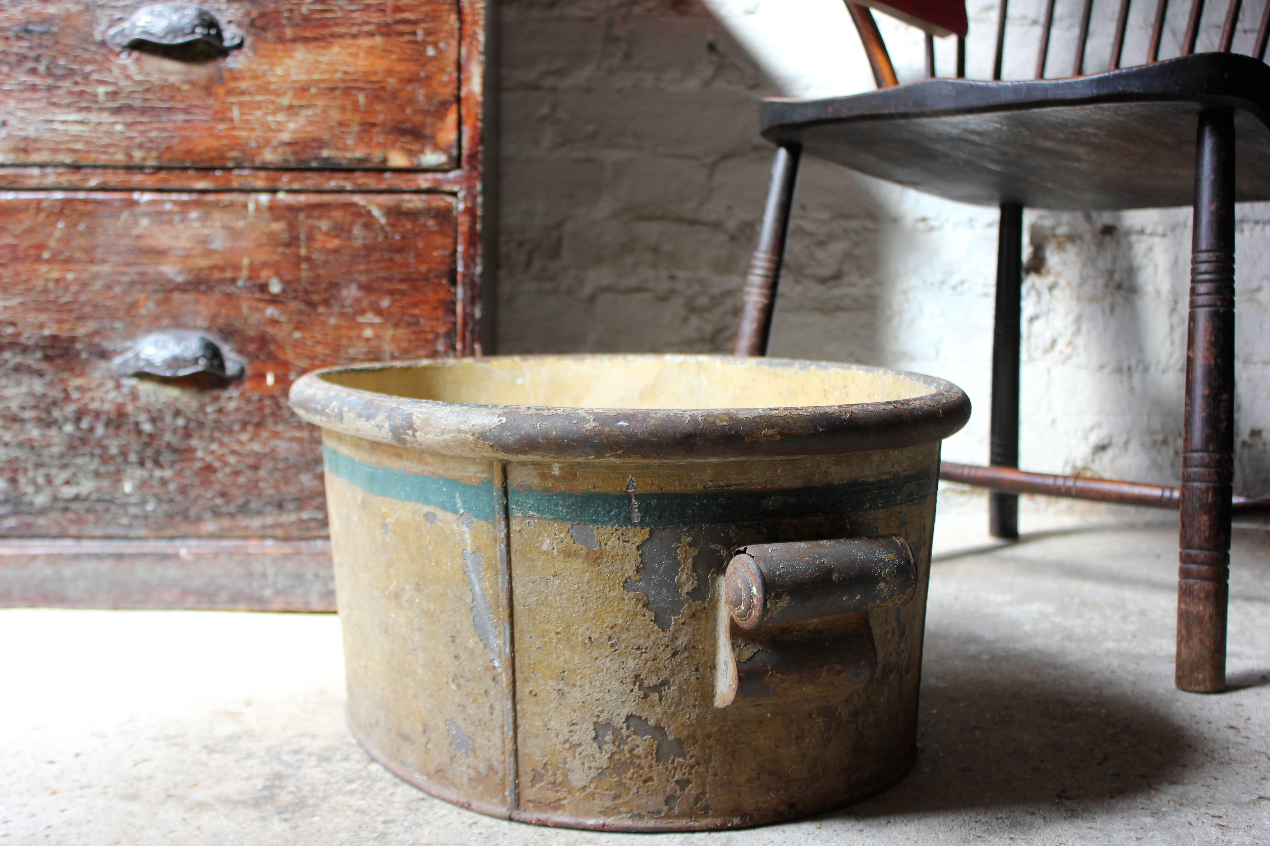 Of ovoid form, the attractive Regency period hand-painted toleware footbath having applied scroll handles, the lemon yellow basin with a single turquoise band to the upper section, in very much the Regency taste, with remnants of a red painted band