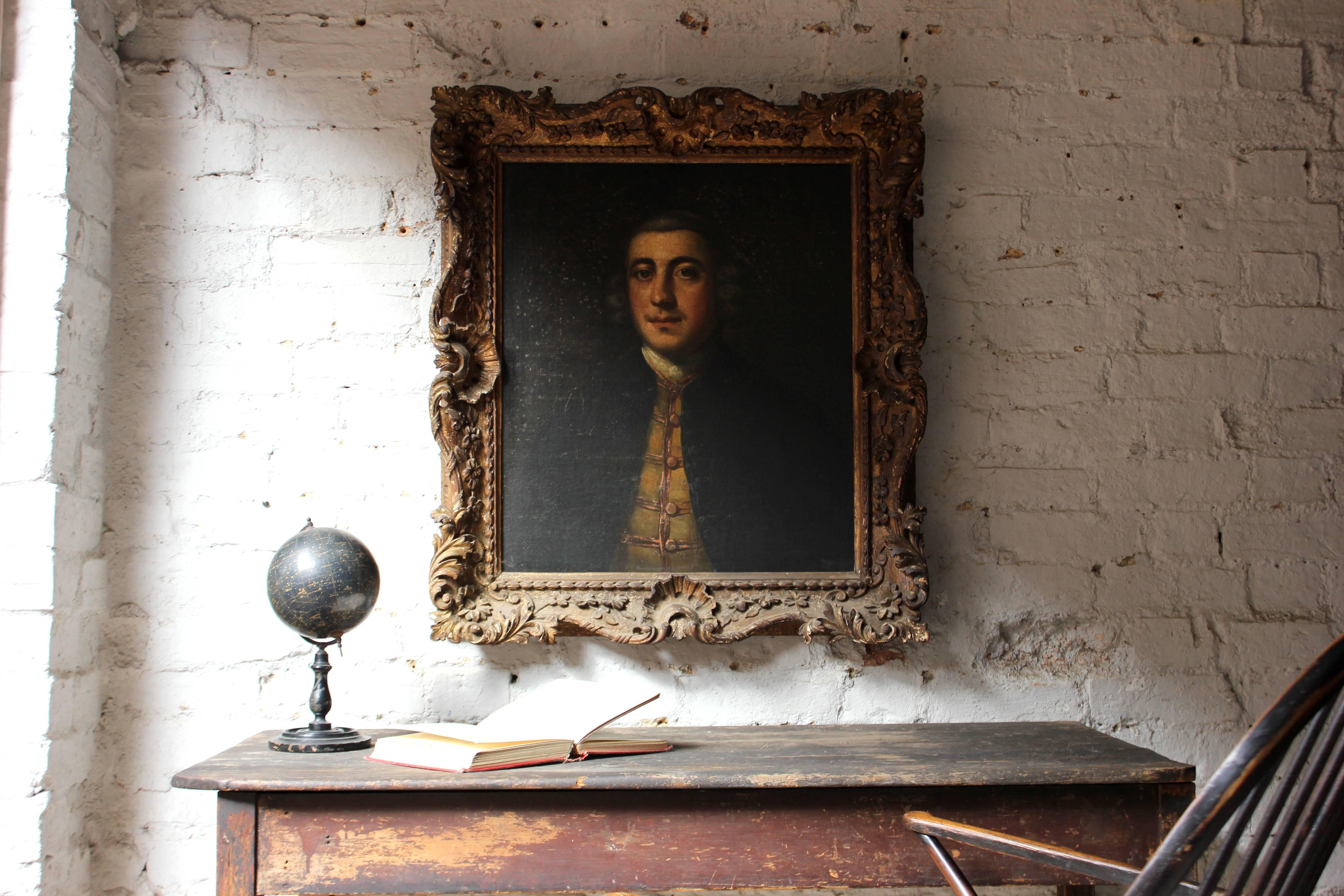The captivating Provincial school oil on canvas portrait of Lumley Arnold, of Ashby Lodge, Northamptonshire (1723-81), housed in the superb original gilt gesso ornamental frame, the sitter shown at head and shoulders length depicted on a dark