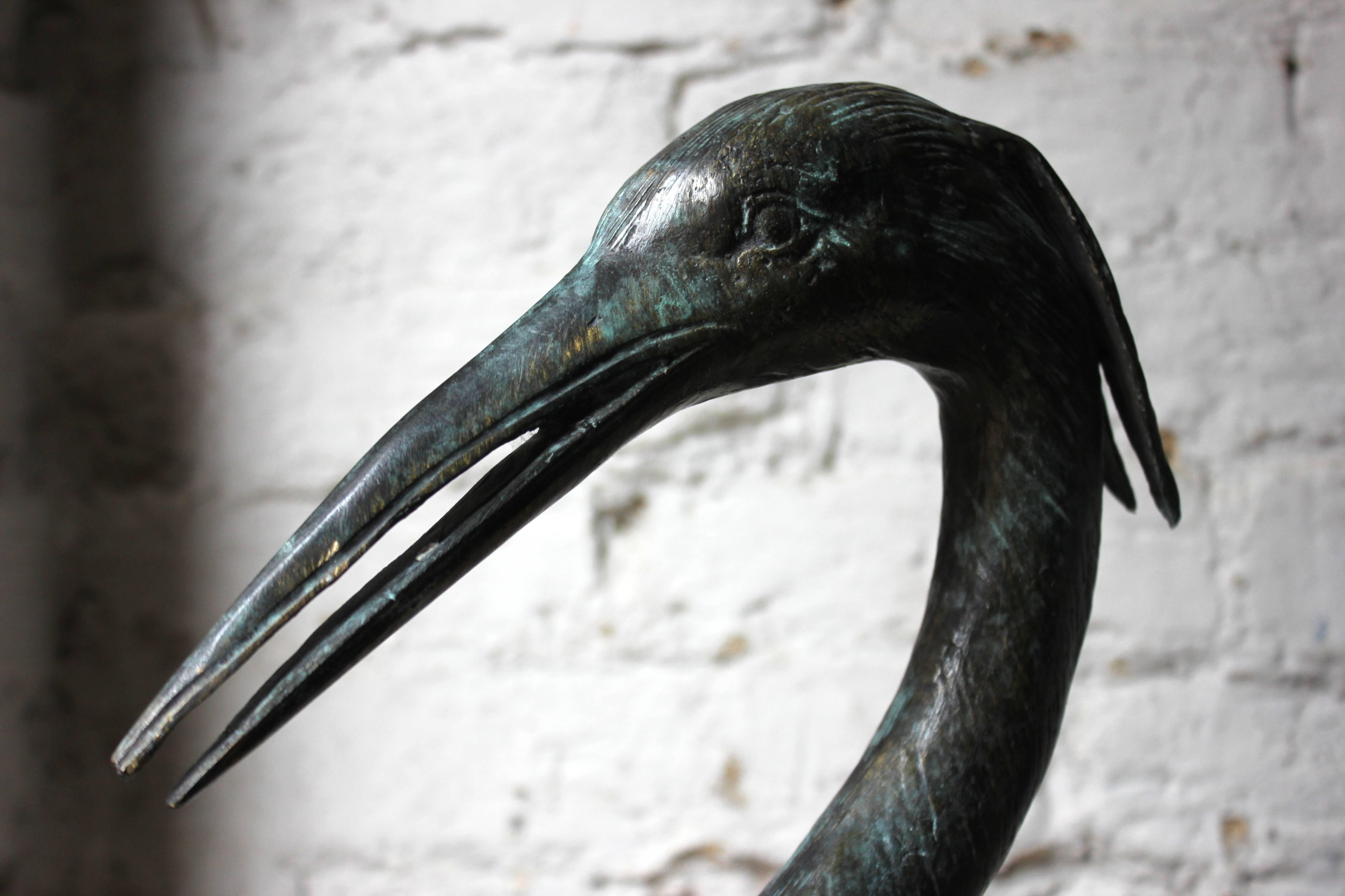The hugely decorative lifesize patinated verdigris hollow cast bronze models of herons, well cast, one with mouth agape and the other closed and freestanding without bases, showing a healthy patina and surviving from the third quarter of the 20th
