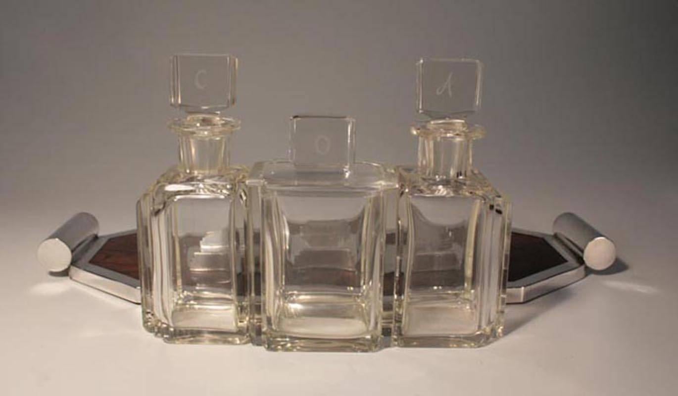 An Art Deco walnut and silver plate three bottle Tantalus, the silver plate frame stamped 