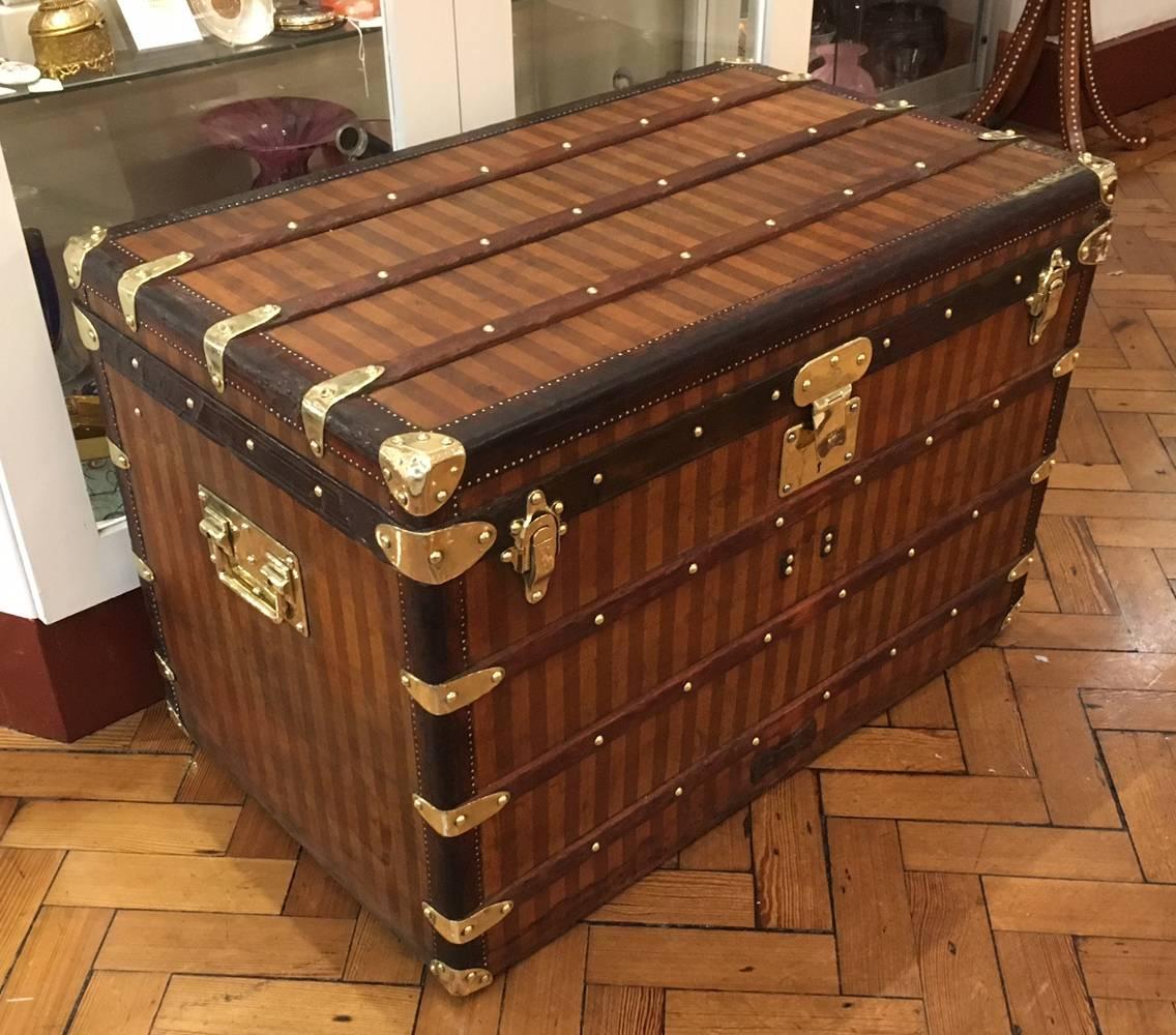 A very nice Louis Vuitton striped canvas (Rayee) courier trunk, circa 1885.

Having one central square lock and two outer clasps, full leather edging and brass hardware.

Also having it's original interior trays and a lovely patina