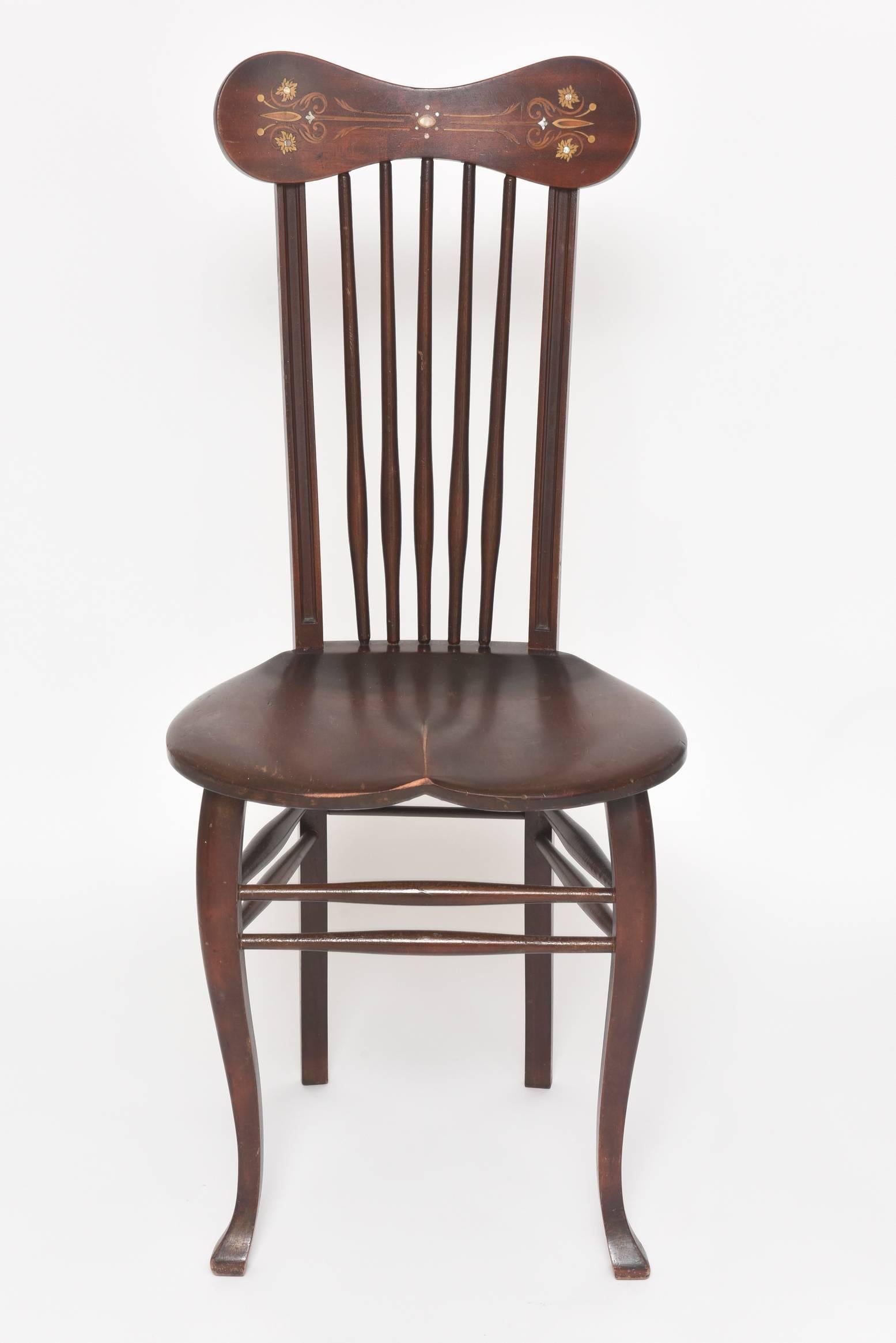 19th century Windsor chair featuring a mother-of-pearl and marquetry design on the top comb section which is connected to a spindle back that attaches to a saddle slab seat with curved front legs that have padded feet.