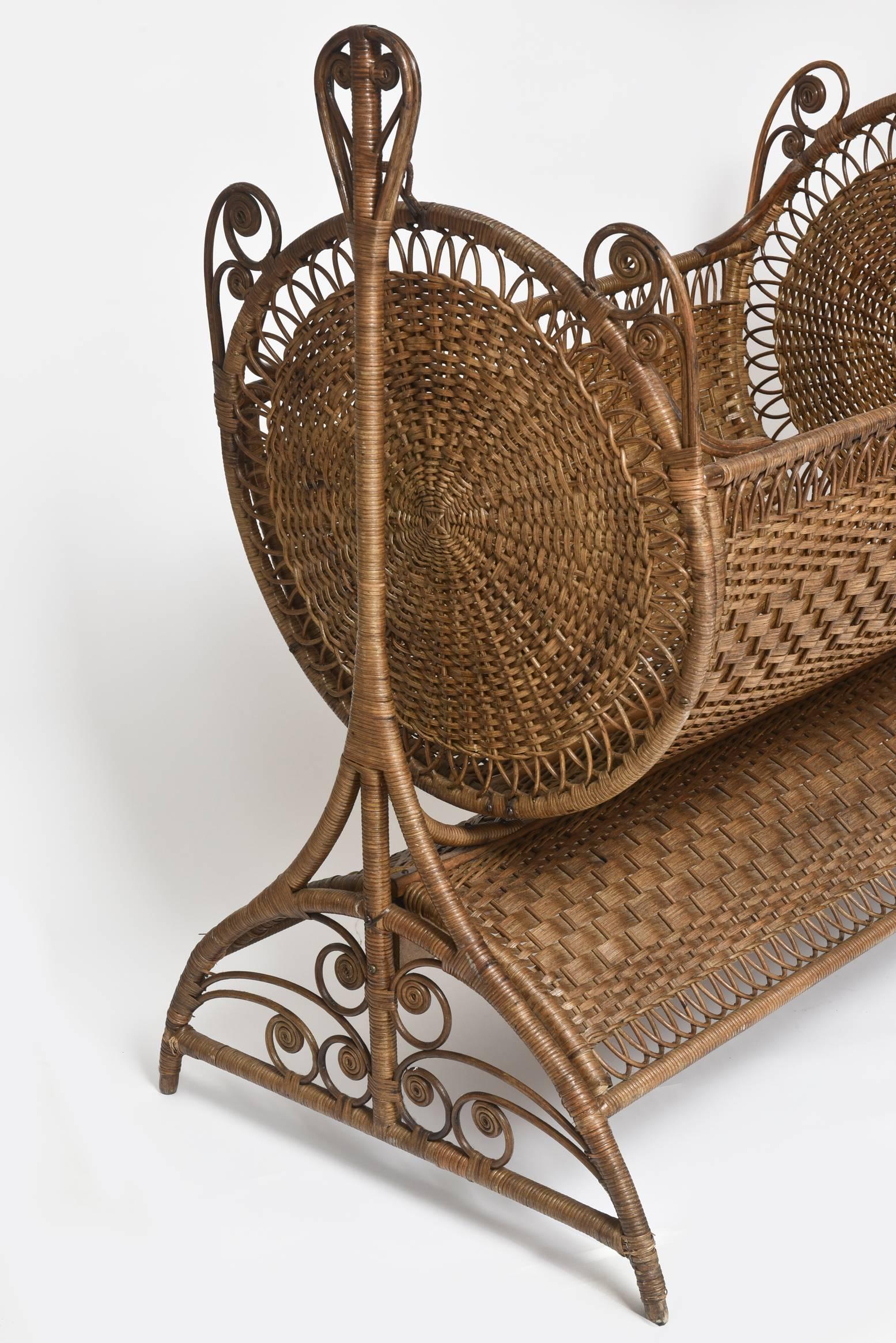The crib includes a detachable wicker crown which holds mosquito netting to be draped over the cradle as a canopy to protect the baby from insect bites. (The swinging cradle is held by two brass joints and sits on a four-legged base.) It is tightly