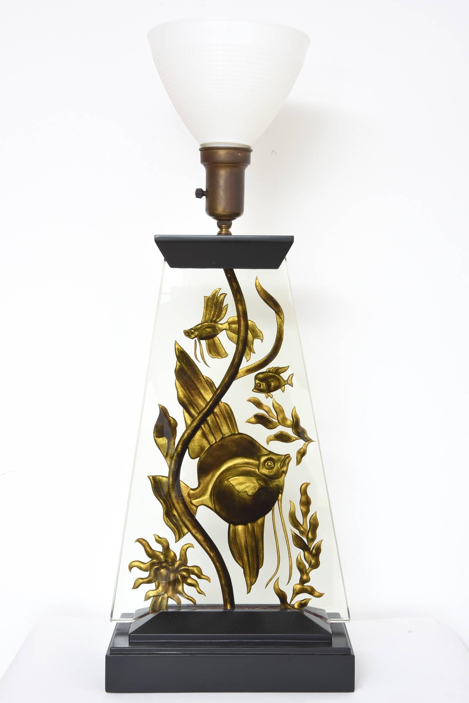 Fantastic example of our Art Deco era.
This Art Deco lamp can also be as mood lighting since you can also illuminate the fish from the bottom. Beautifully made with the fish being etched into the glass and then painted gold. The bottom is lacquered