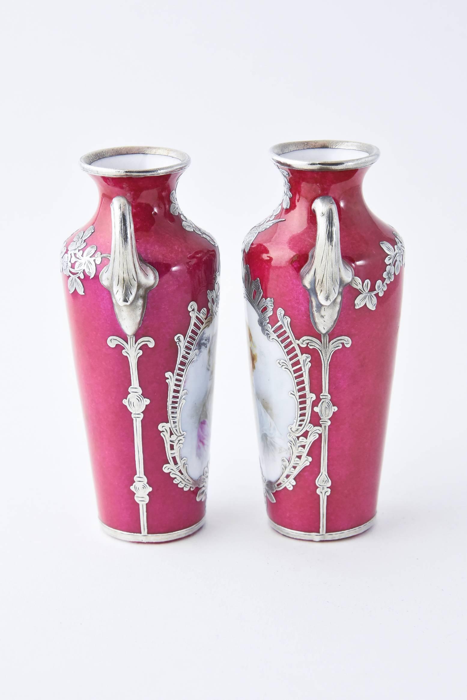 Pair of tiny beautiful porcelain vases / urns each featuring a hand painted portrait in an ornate sterling silver overlay frame with floral and bird accents.