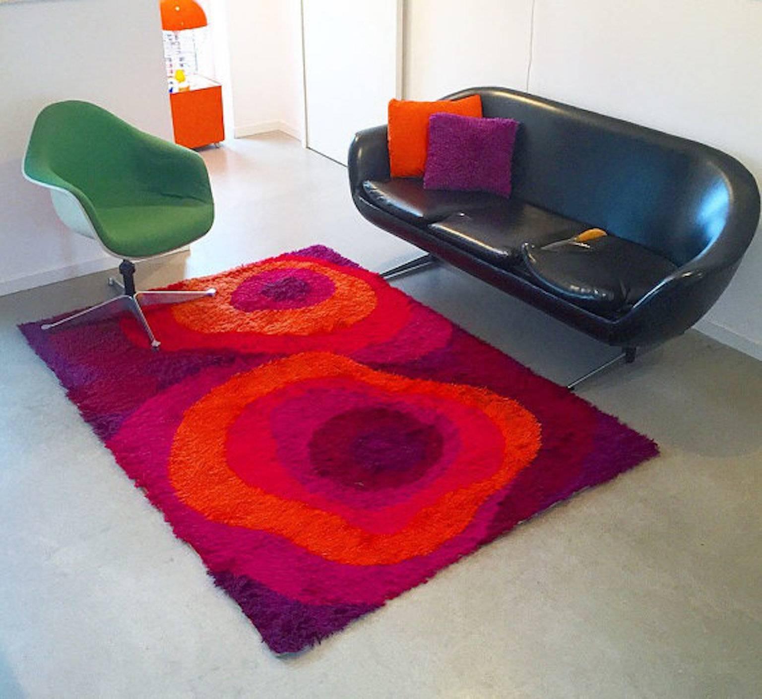 This gorgeous thick pile Rya rug was designed by in-house designer Carin Agner Nielsen for Ege Taepper of Denmark around late 60s or early 70s.

The abstract pattern of red and purple colors leads you right back to the era of Verner Panton, where