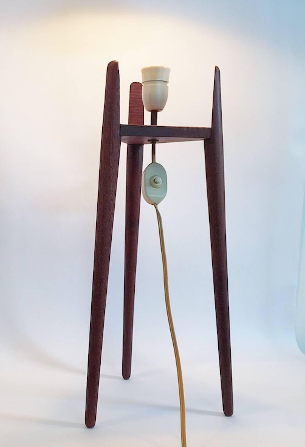 Amazing floor lamp designed in the 1950s with lovely details. The tripod base holds the bulb holder and the original shade. 

The shade is made of celluloid with a woven structure and has beautiful brass details at the bottom and the top. 

The