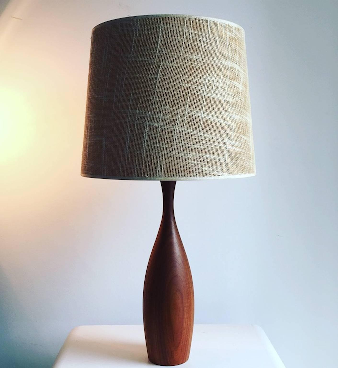 This beautiful and well kept large teak table lamp was designed in the 1960s in Denmark.

The bottle shaped lamp is turned in one piece of solid teak. Although the lamp is Minimalist the lamp has great details like a Bakelite bulb holder and an