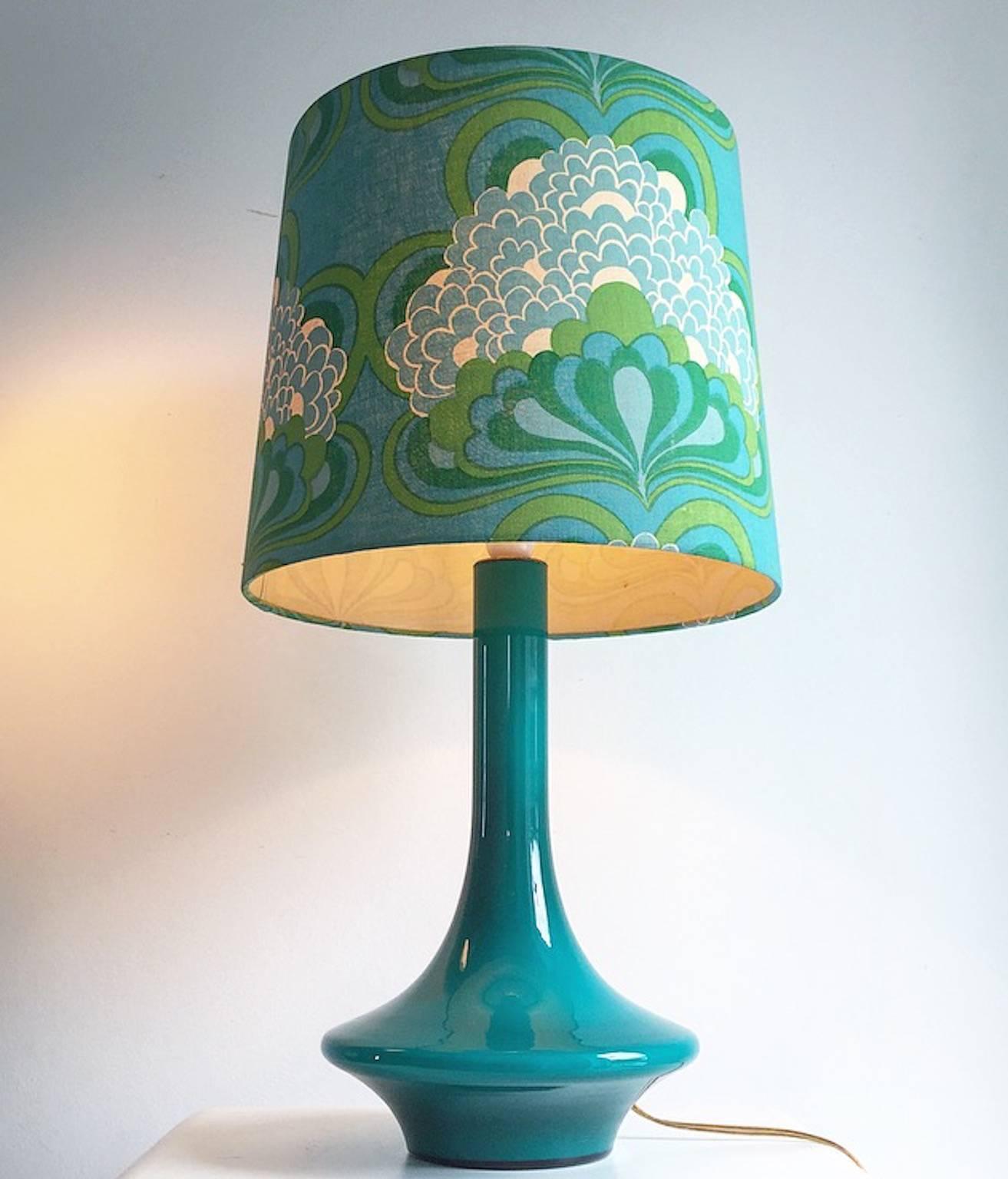 Amazing and rare colorful glass table lamp from Sweden attributed to Orrefors glass, early 1970s.

Both the lamp and the shade have a range of green and turquoise colors. The shade is original bought together with the lamp.

A beautiful