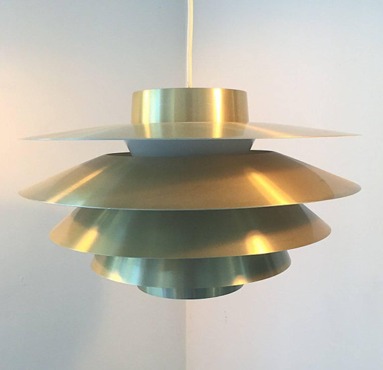 Svend Middelboe made this iconic Verona brass pendant for Nordisk Solar back in the 1960s.

Five individual shades makes this pendant an eyecatcher lit or unlit. 

Condition: Close to mint condition. 

Light source: E27 Edison screw fitting