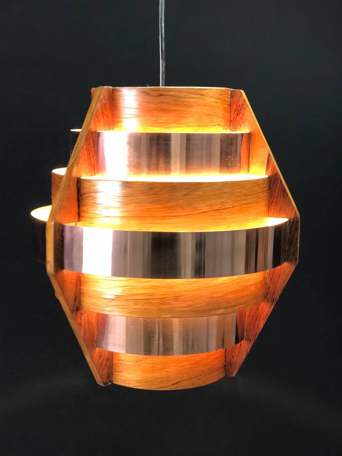 Walnut veneer and three massive copper rings is what makes this stunning piece of Scandinavian Mid-Century design.

Condition: Few age related signs such as small pieces of veneer missing which doesn´t effect the overall beauty of the pendant.