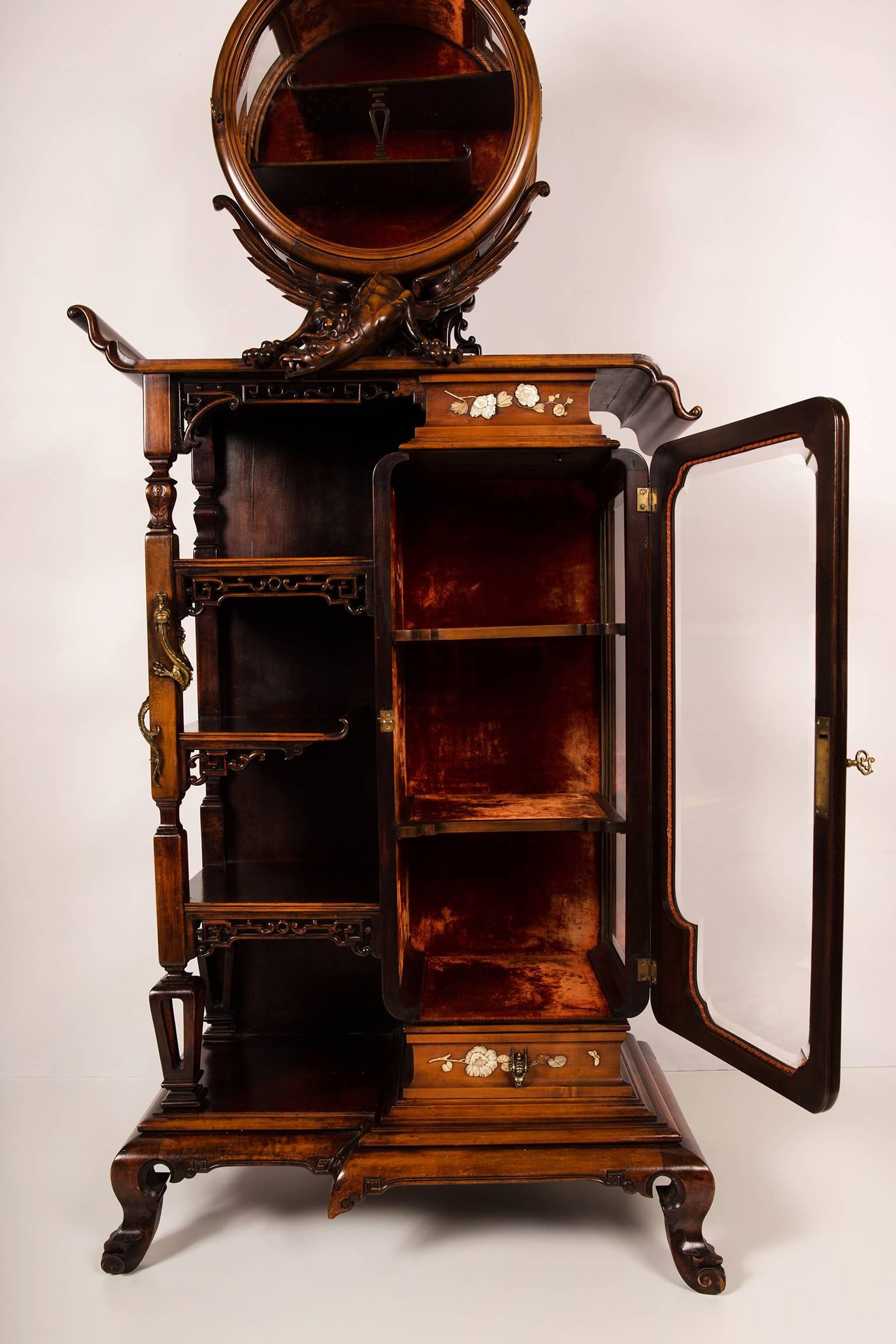 An interesting and rare example of chinoiserie or Japonisme, this collectors vitrine with etagere can be dated circa 1890. Based on the use of similar forms, French 19th century applied arts specialist Mrs. Daisy Maison attributes this piece of