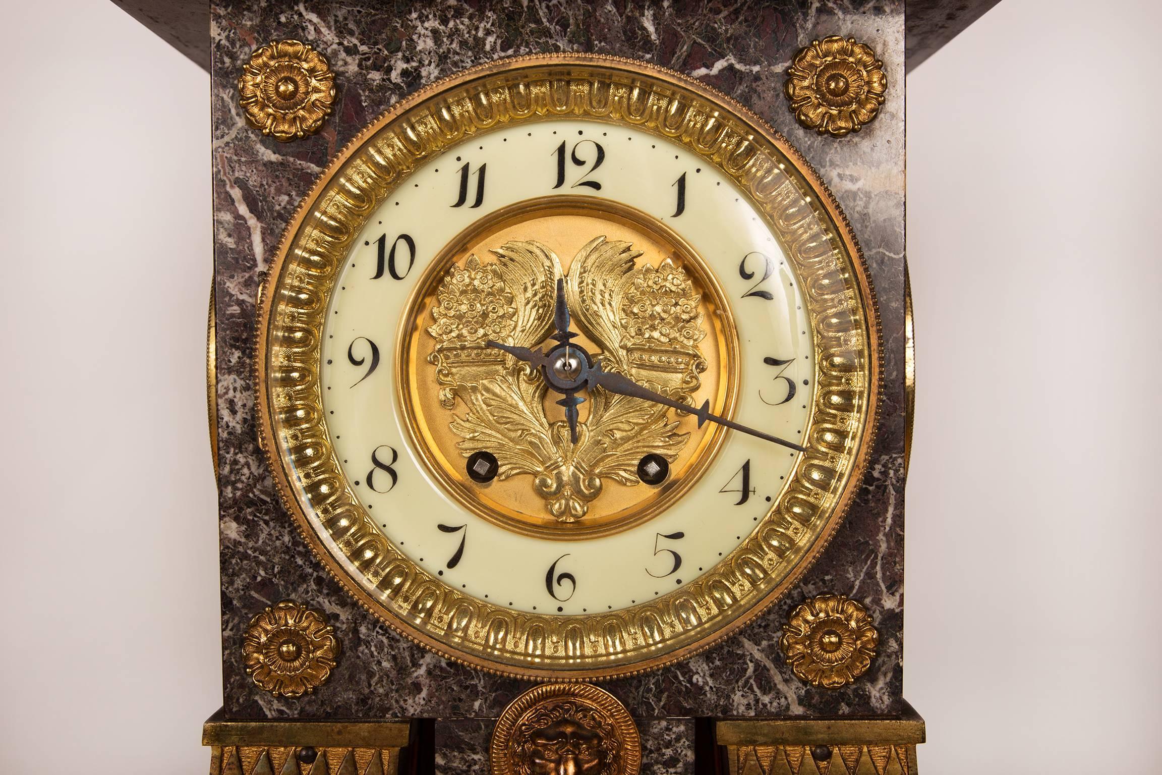 A very decorative Levanto Rouge marble tapering column in the Empire style with an eight-day going clock, strike on the hour. Adorned with Empire style gilt brass ornaments, horns of plenty on the sunburst pendulum and the dial.
The arabic hours