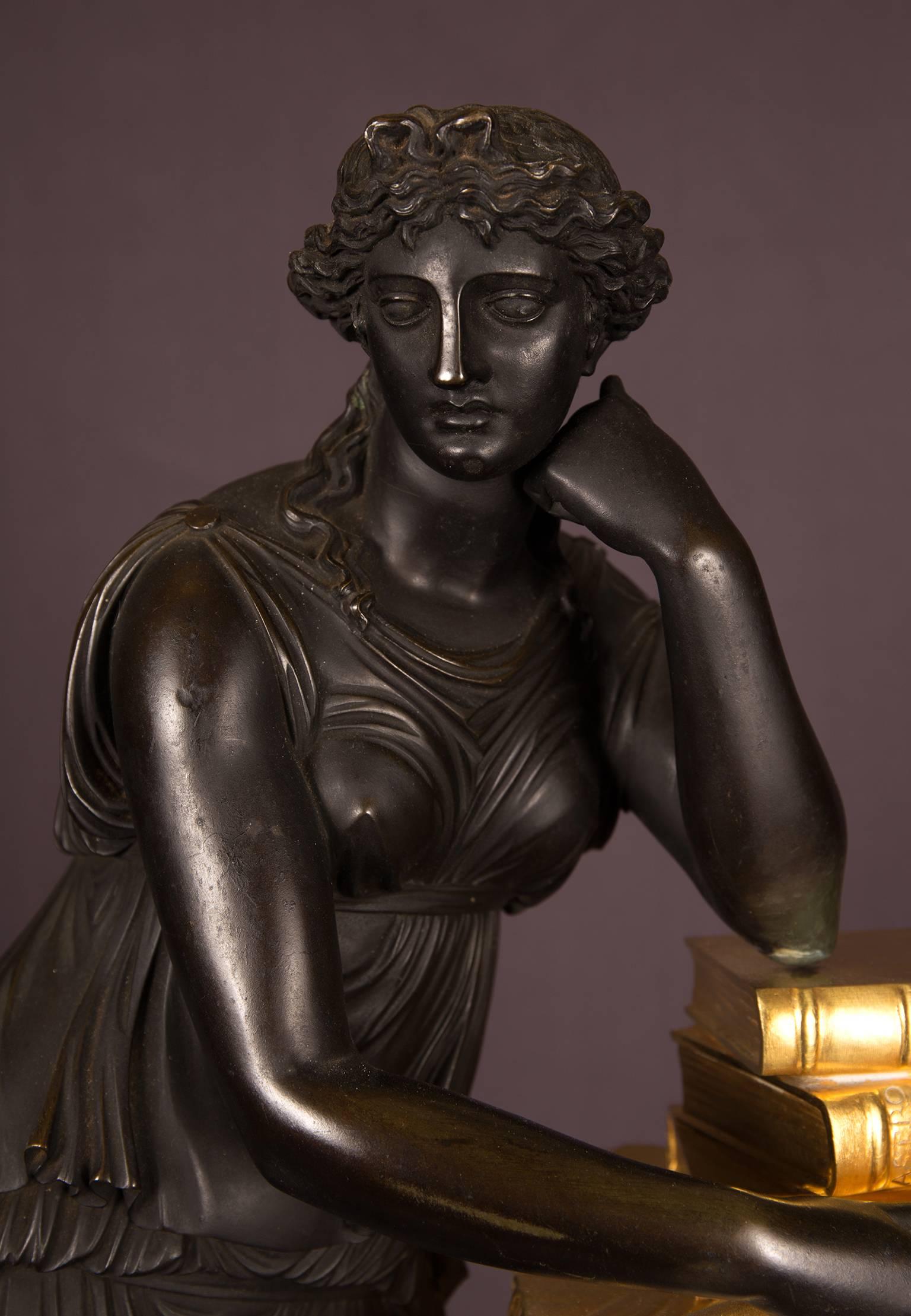 Empire period mantel clock representing the figure of Study, France, circa 1815. Possibly after a model by the French bronzier Pierre Victor Ledure. A classical female figure, symbolising Study, leans on books by Aristoteles and Homerus. A gilt