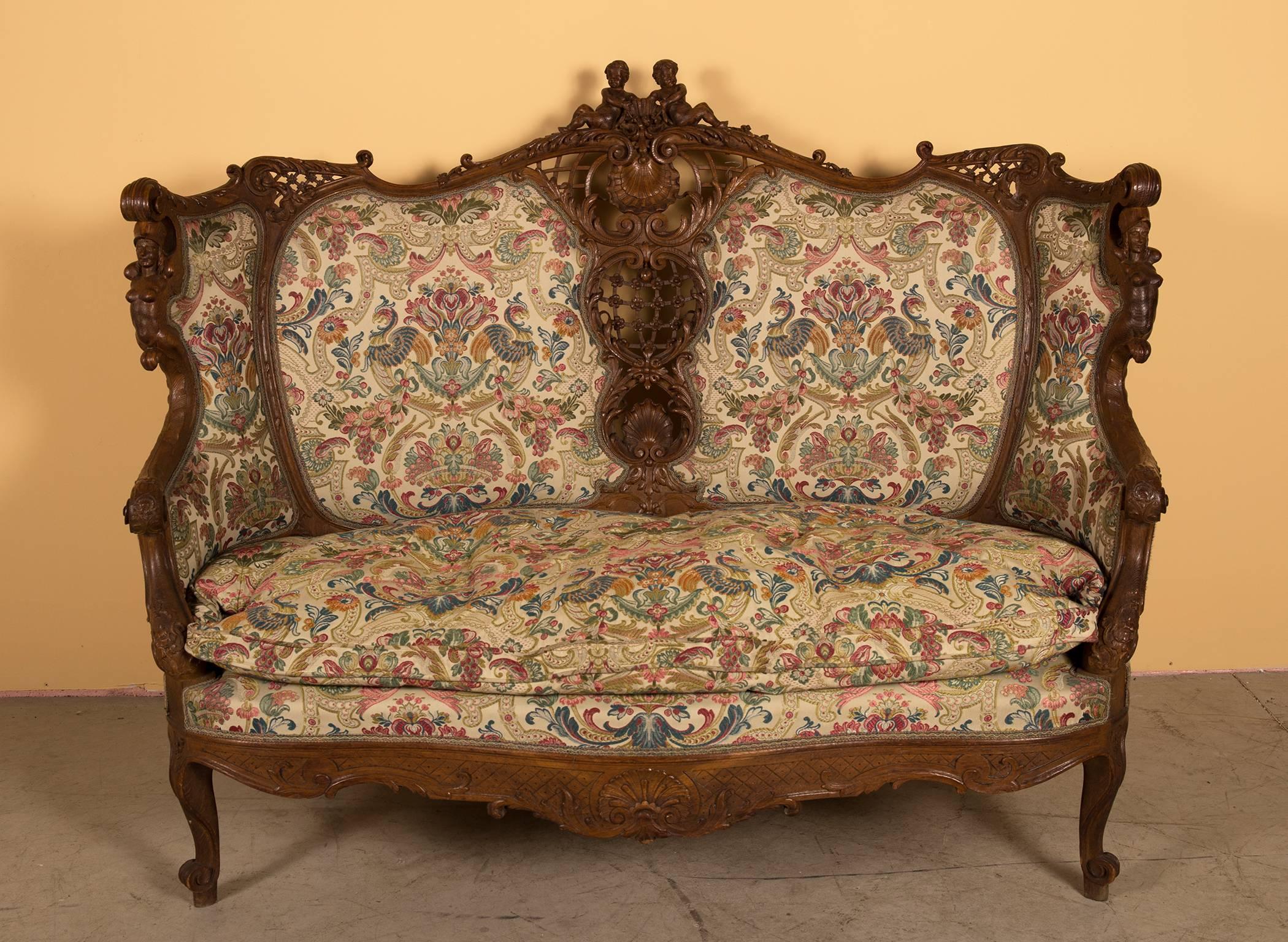 A three-piece Salon Suite with matching four-fold screen all in carved oak with luxurious upholstery and in good condition. One sofa and a pair of bergère chairs, the screen with four leaves of wood carved on the front and backside, cut-glass and