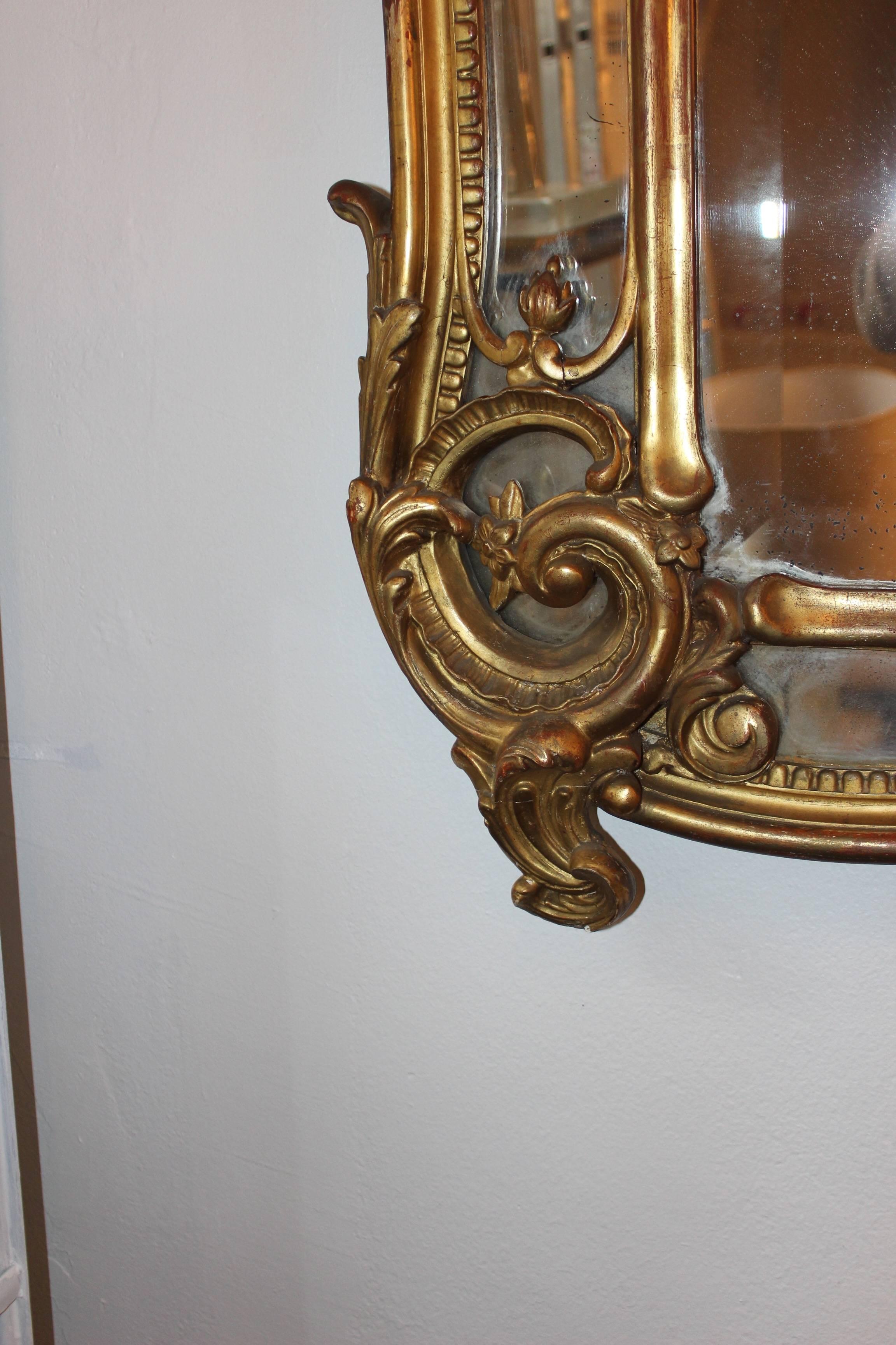 Large French Regency style gilt mirror, mid-19th century. Makes an elegant statement in any interior.