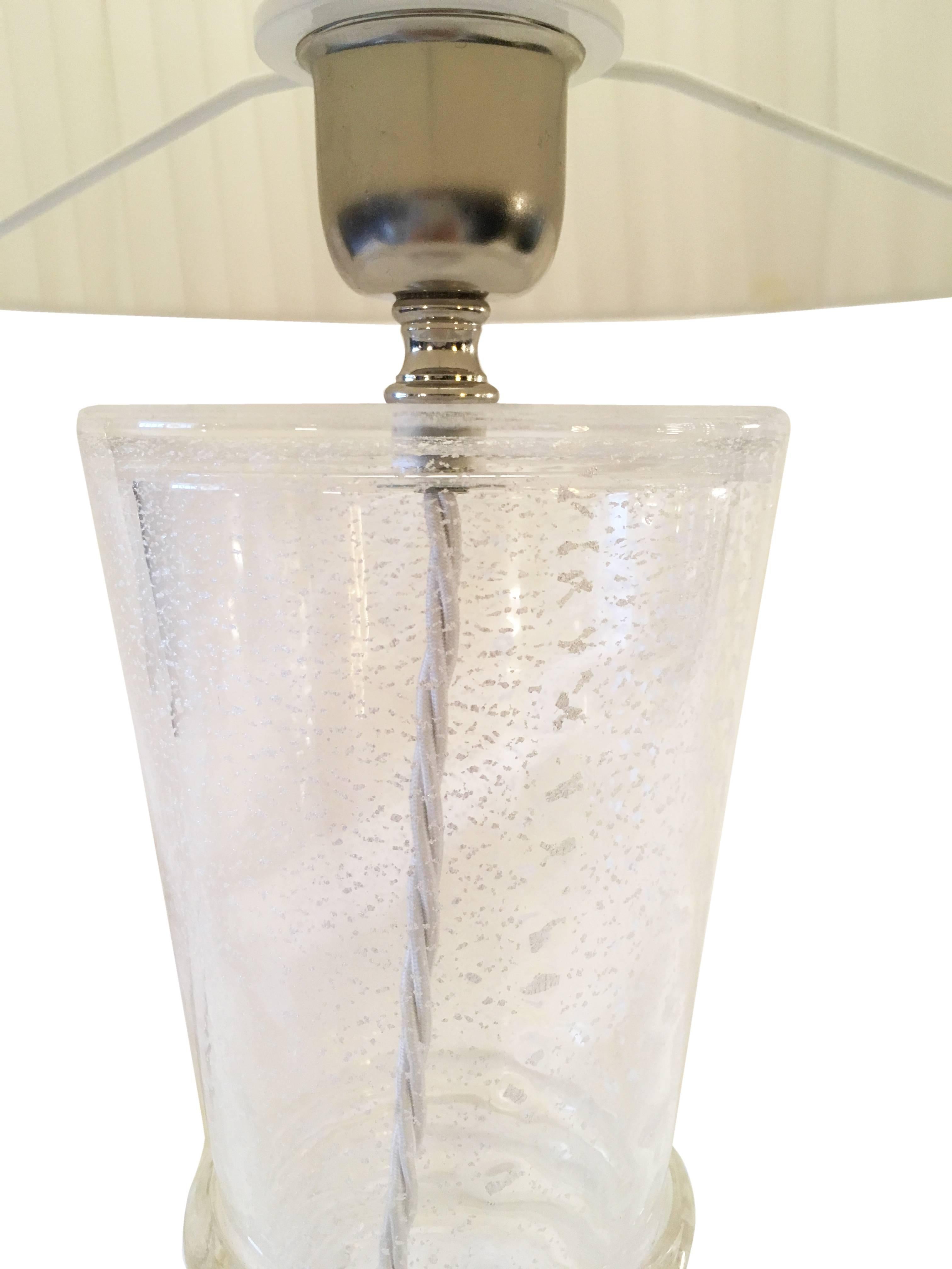 This item includes all taxes for delivery to the USA or the EU.

Elegant table lamp in clear glass with silver dust. 
1 x E27 bulb fittings.
Â Â 