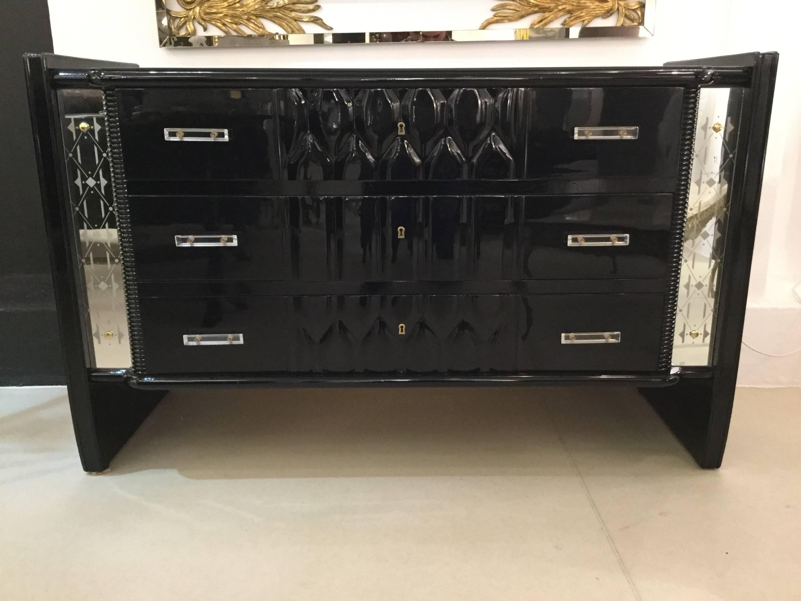 An elegant Art Deco chest of drawers in black lacquered wood with Lucite handles and two engrave mirrors on the front sides.
In excellent condition.