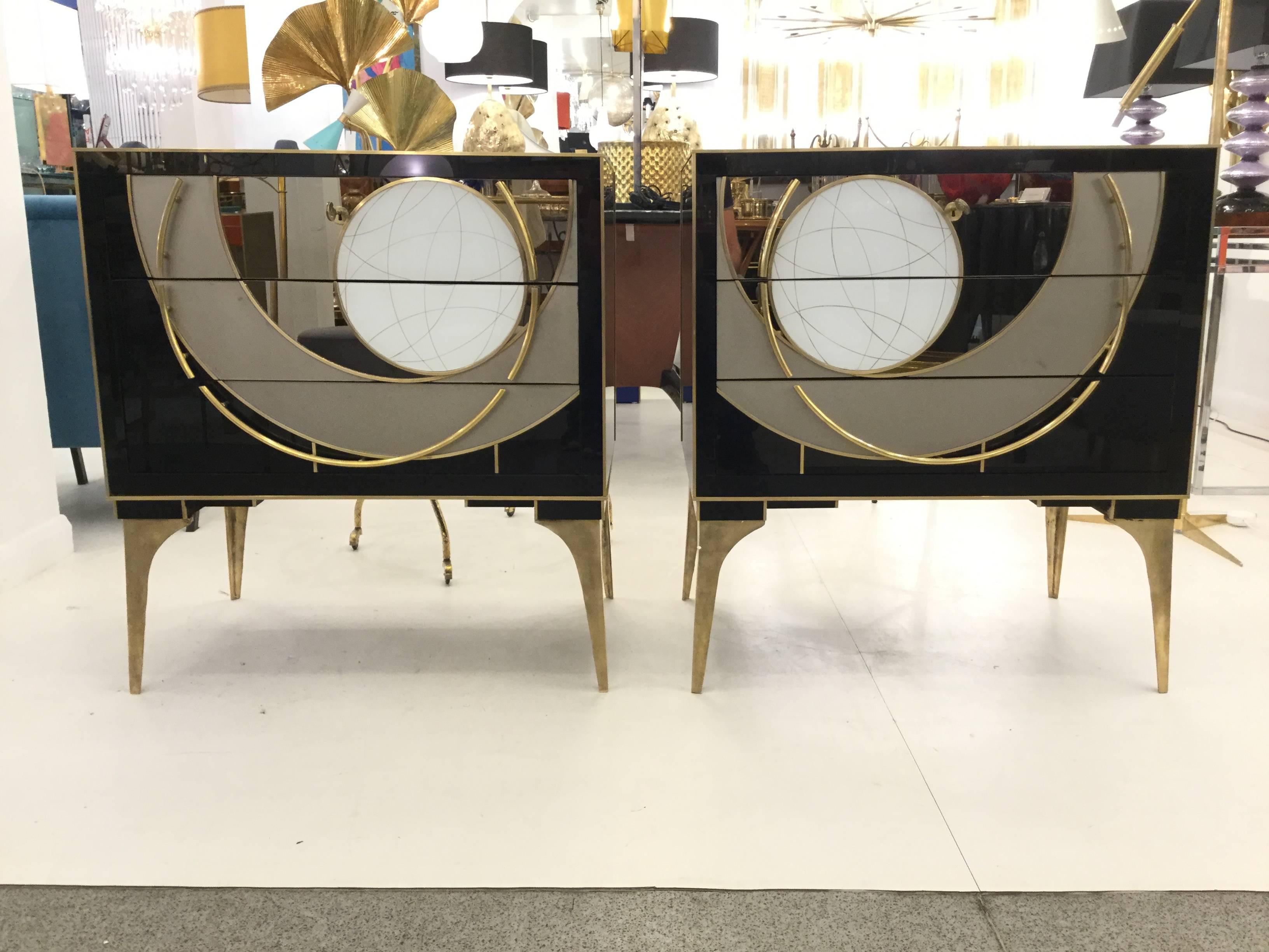 A pair of artistic Italian designed Venetian chests, glass with brass hardware and tapered legs with a geometric design across the three drawers, circa 1970.
