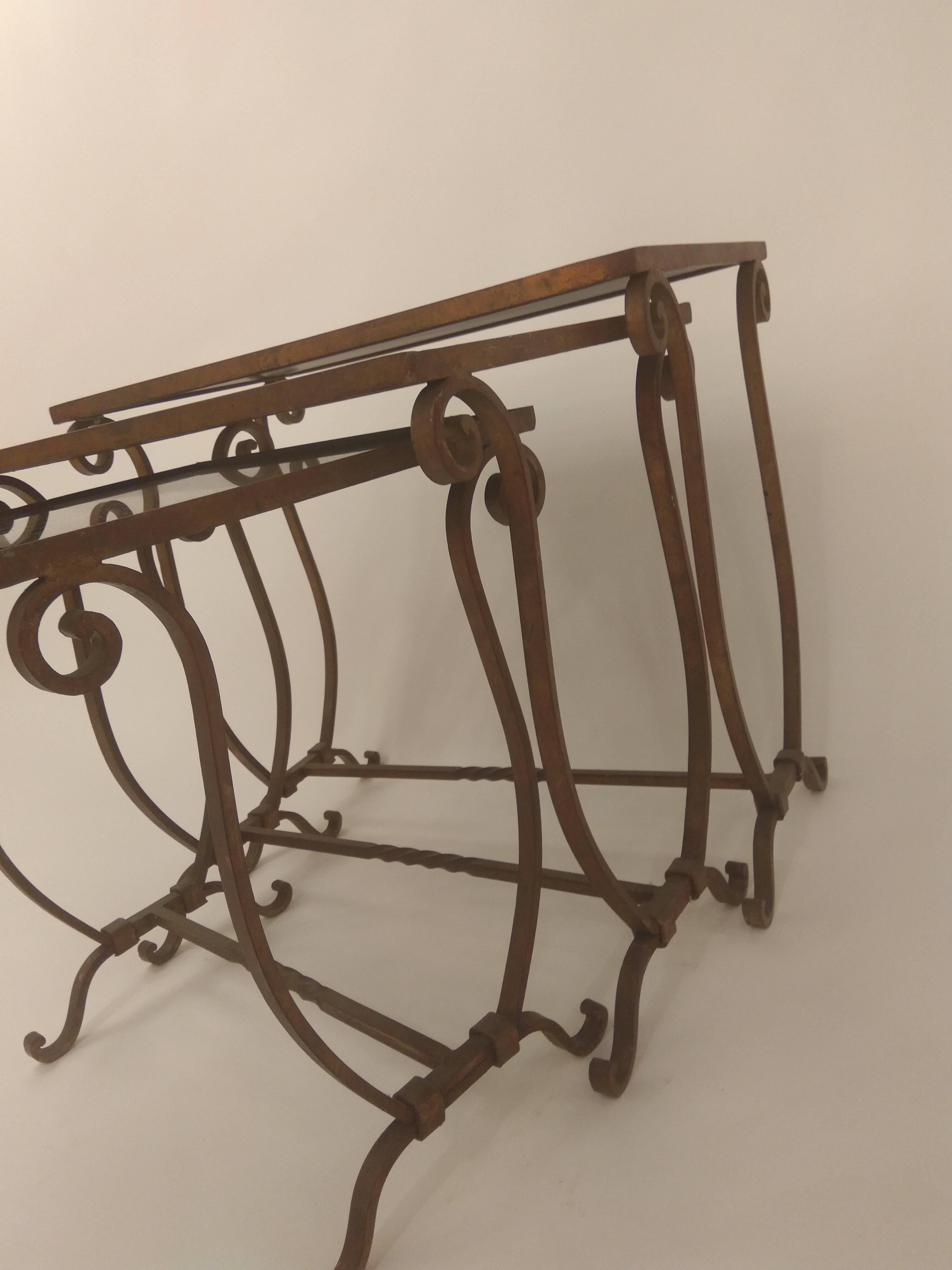 An Italian designed nest of three tables with base and legs in bronzed painted forged iron with black glass tops, 1950.