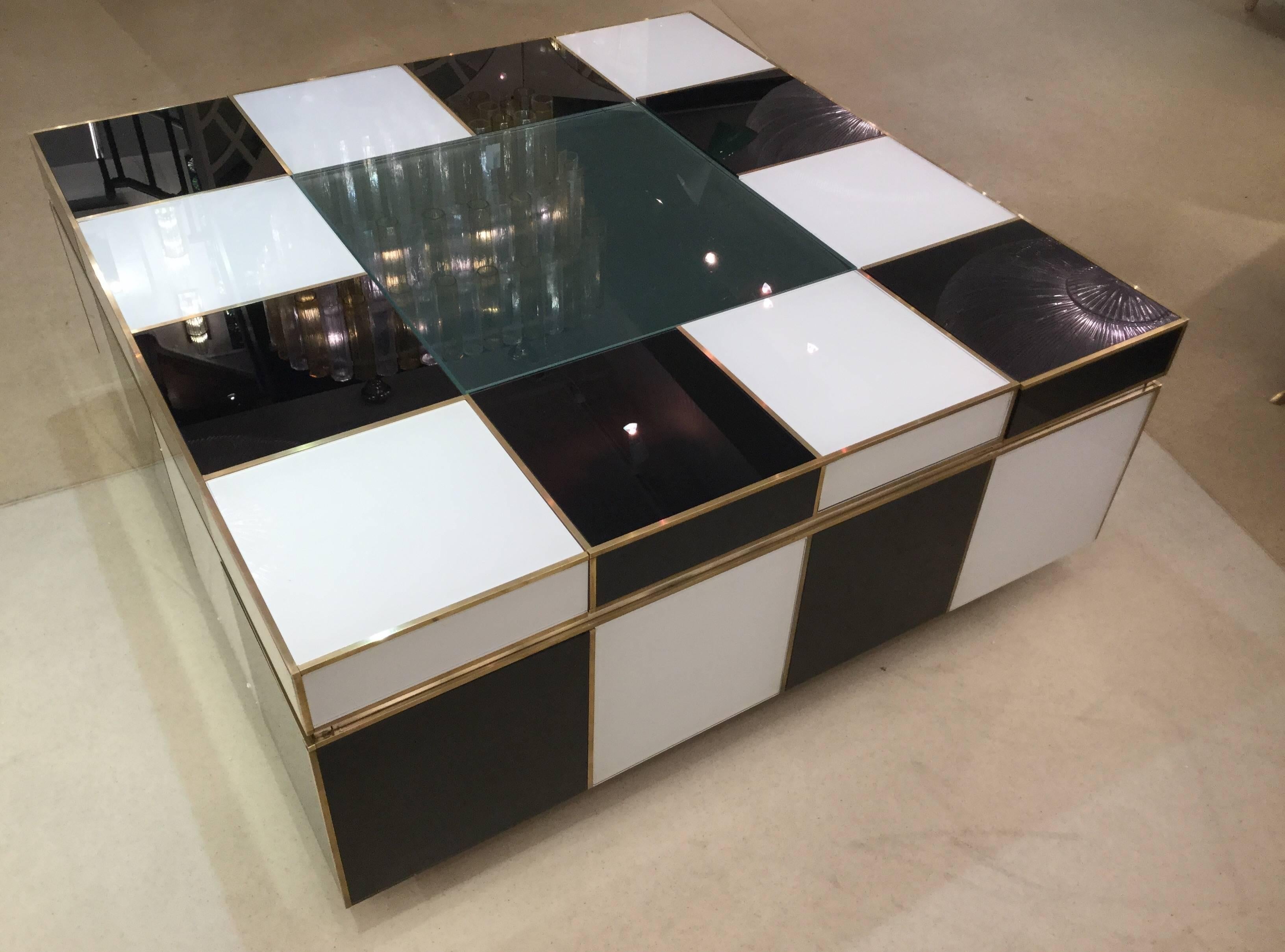 Italian 1970 coffee table in white and black glass. The top extends and the centre glass comes off to reveal an interior compartment.

Measures: cm 135 W X 101 D X 42 H (open).
 cm 101 W X 101 D X 42 H (close).