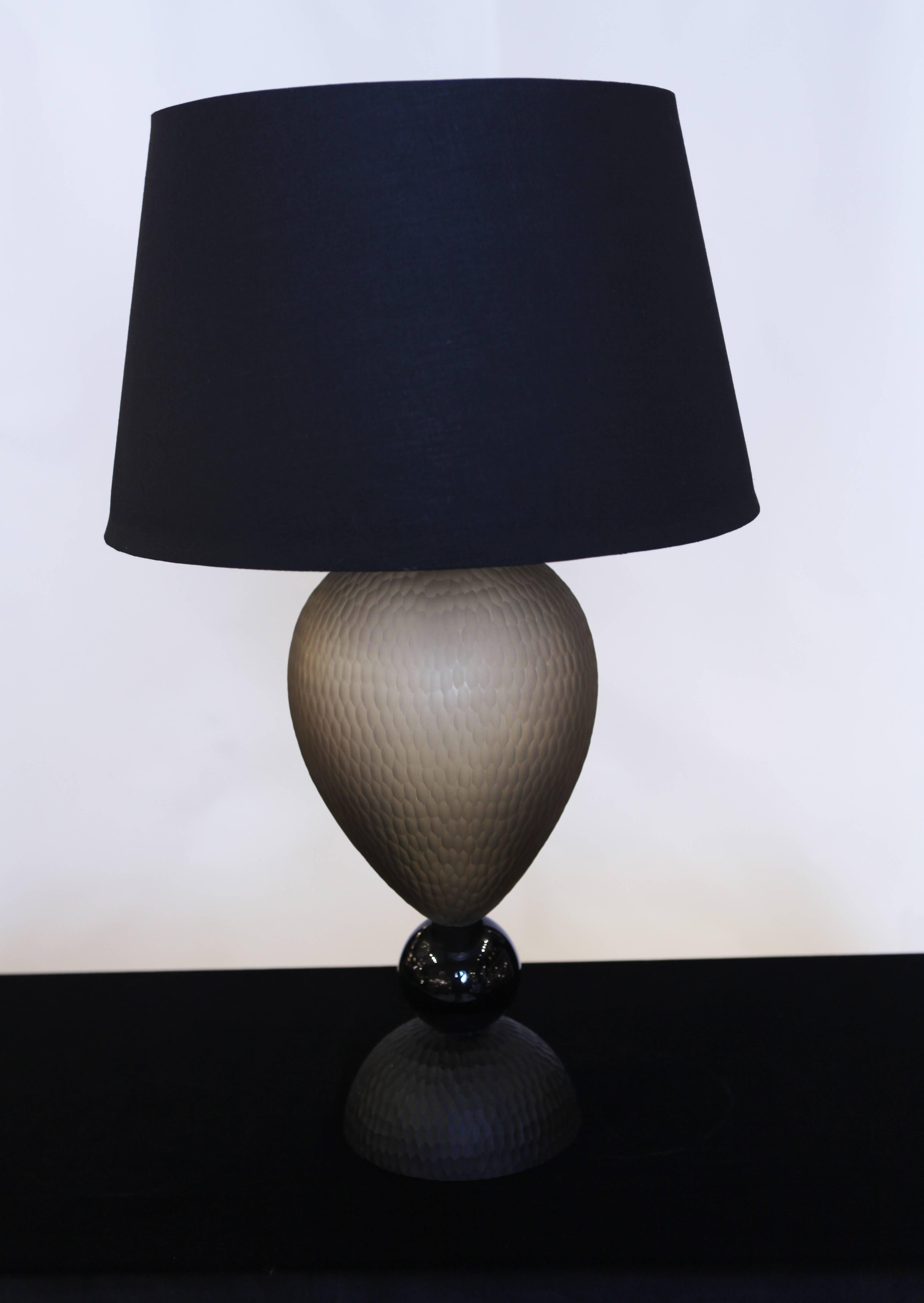 A beautiful pair of Venetian glass table lamps. The base, in faceted black glass   sustains a beautiful black Venetian glass sphere and grey egg-shaped piece in faceted glass
