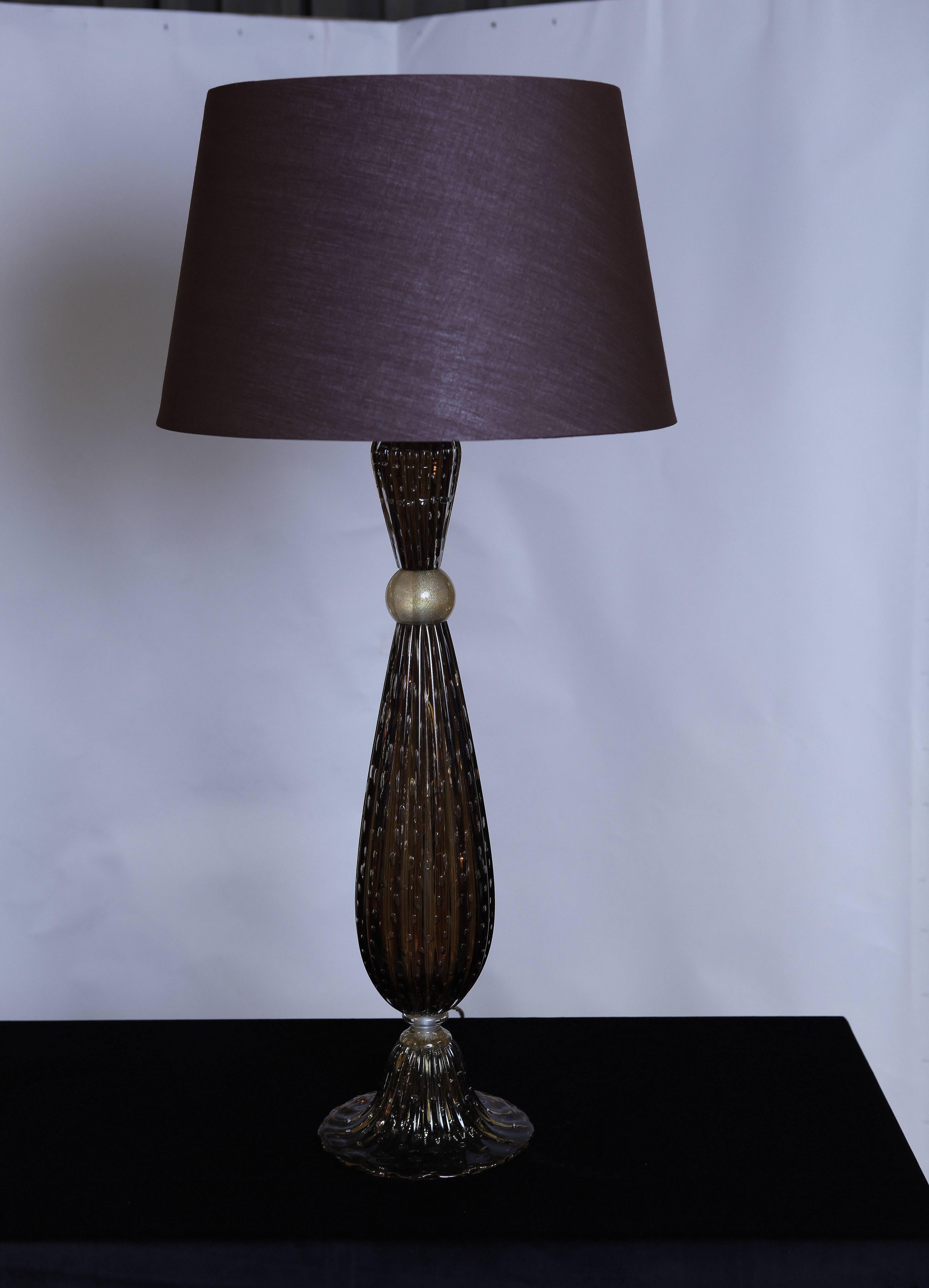 A beautiful pair of Murano glass table lamps in dark amber color.